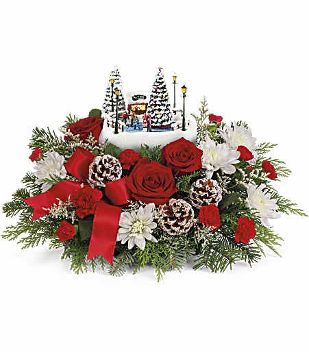 Thomas Kinkade's Skate Into the Holidays Bouquet - Create joy with this enchanting holiday gift! Hand-painted and nestled among a bouquet of winter roses and ornaments, this light-up Thomas Kinkade collectible celebrates the timeless magic of Christmas caroling. It's a perfect present or centerpiece for the holiday season.  Celebrate the holidays with this festive bouquet featuring red roses, miniature red carnations, white cushion spray chrysanthemums, and white limonium. Accented with noble fir and cedar, delivered in Teleflora's Thomas Kinkade's Oh What Fun Keepsake, it spreads holiday cheer with Thomas Kinkade's Skate Into The Holidays Bouquet. Standard approximately 18&quot; W x 10&quot; H.