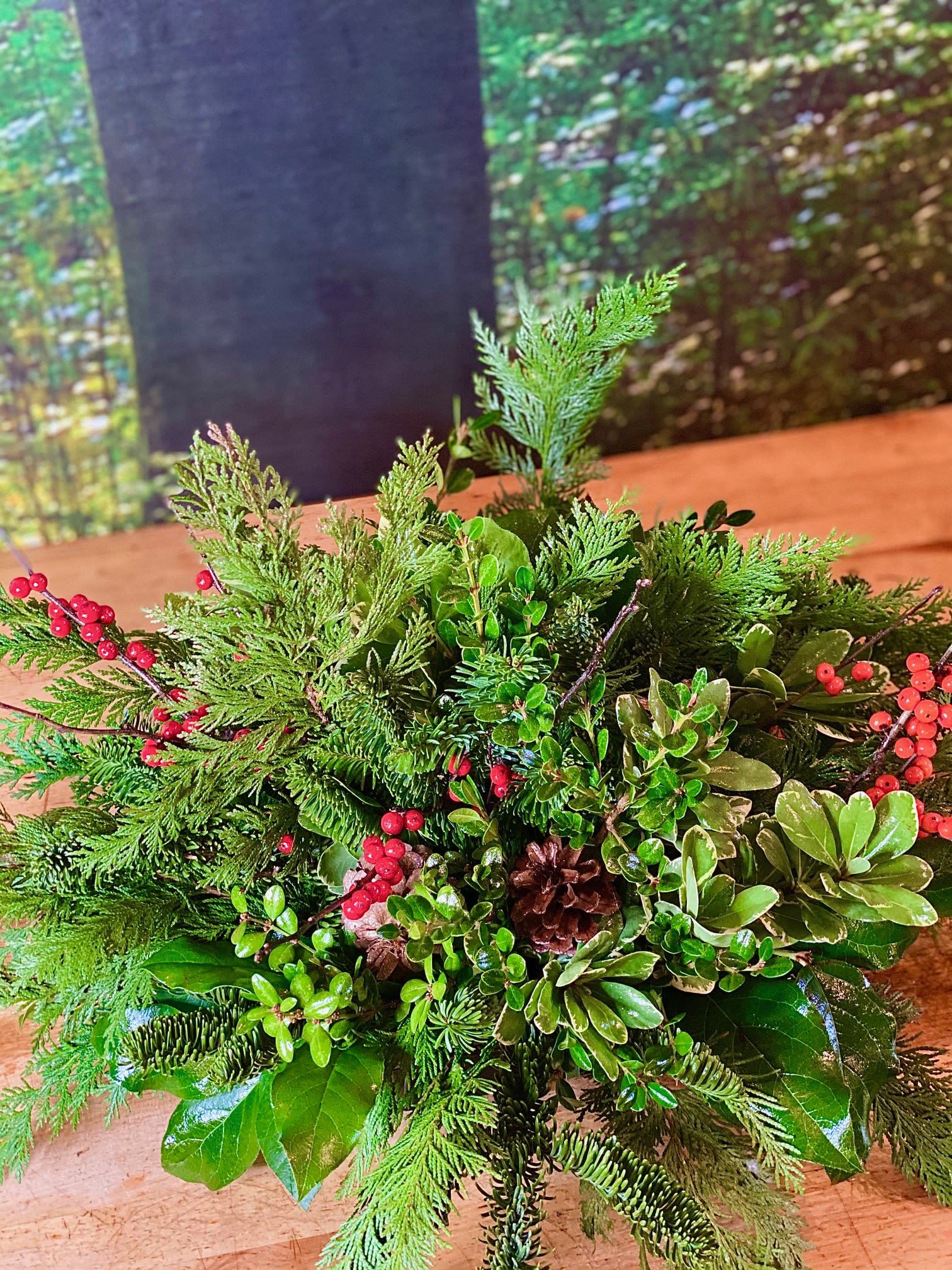 Fragrant Wintergreen  - Give a magical and fragrant gift this winter. This design will spark wonderful memories with the fresh scents of Noble Fir and Port Orford Cedar. This lush woodland design, it also includes winter berries and pinecones arranged in a low dish.