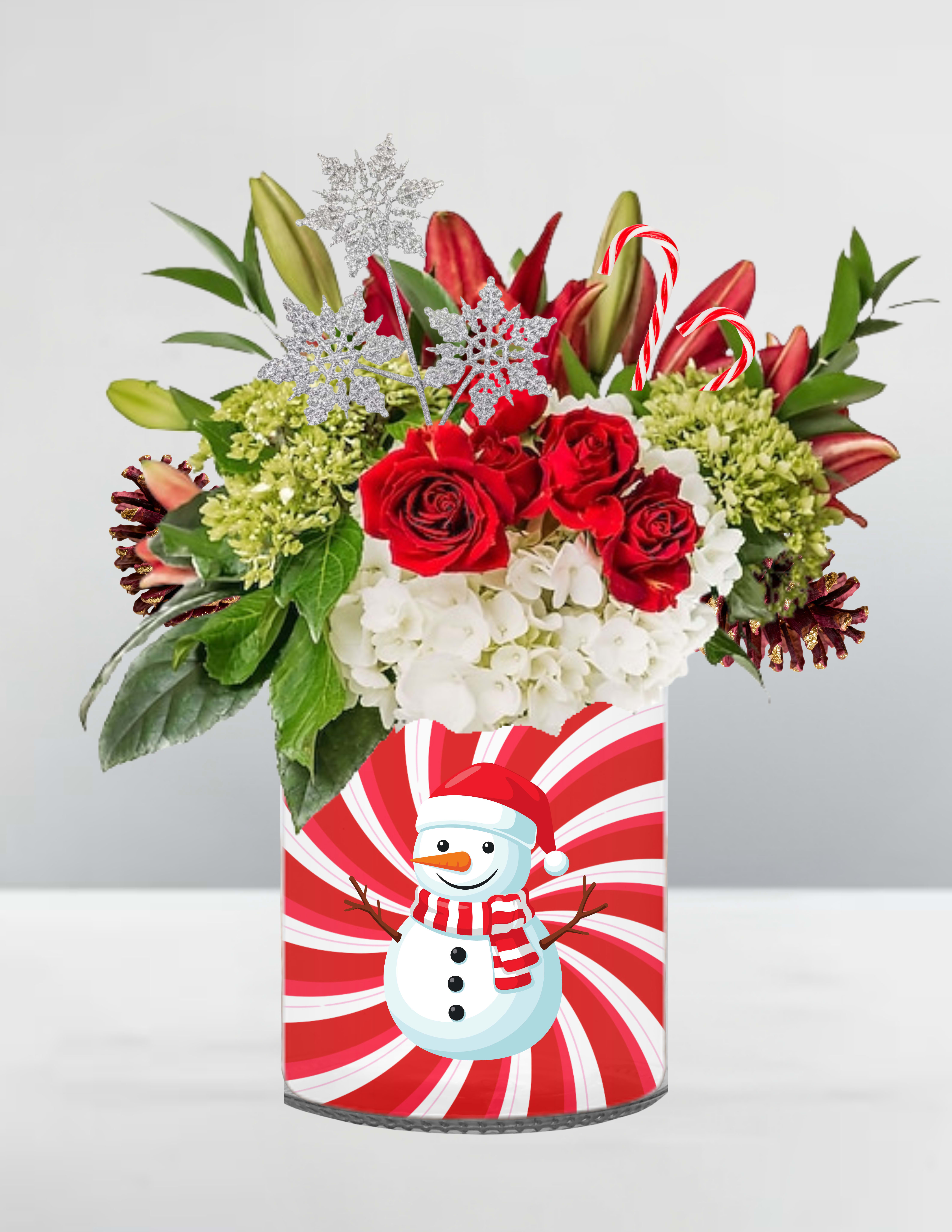 Scarves &amp; Snowflakes - ️ Scarves &amp; Snowflakes  Wrapped in holiday cheer, Scarves &amp; Snowflakes brings the magic of a snowy day to life. Red roses and candy cane lilies burst from a peppermint-swirled vase adorned with a jolly snowman in his striped scarf and Santa hat. White and green hydrangeas nestle among glittering snowflakes and evergreen sprigs, while playful candy canes peek through like winter’s sweet surprise. It’s a joyful blend of cozy charm and frosty sparkle—like a warm hug from Frosty himself.