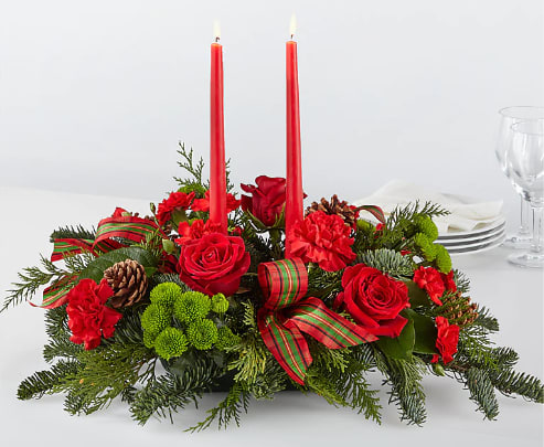By The Candlelight Centerpiece - Let time fly By the Candlelight centerpiece as new holiday memories are made. What better way to commemorate the joyful homecoming than with classic red roses and lush evergreen accents?