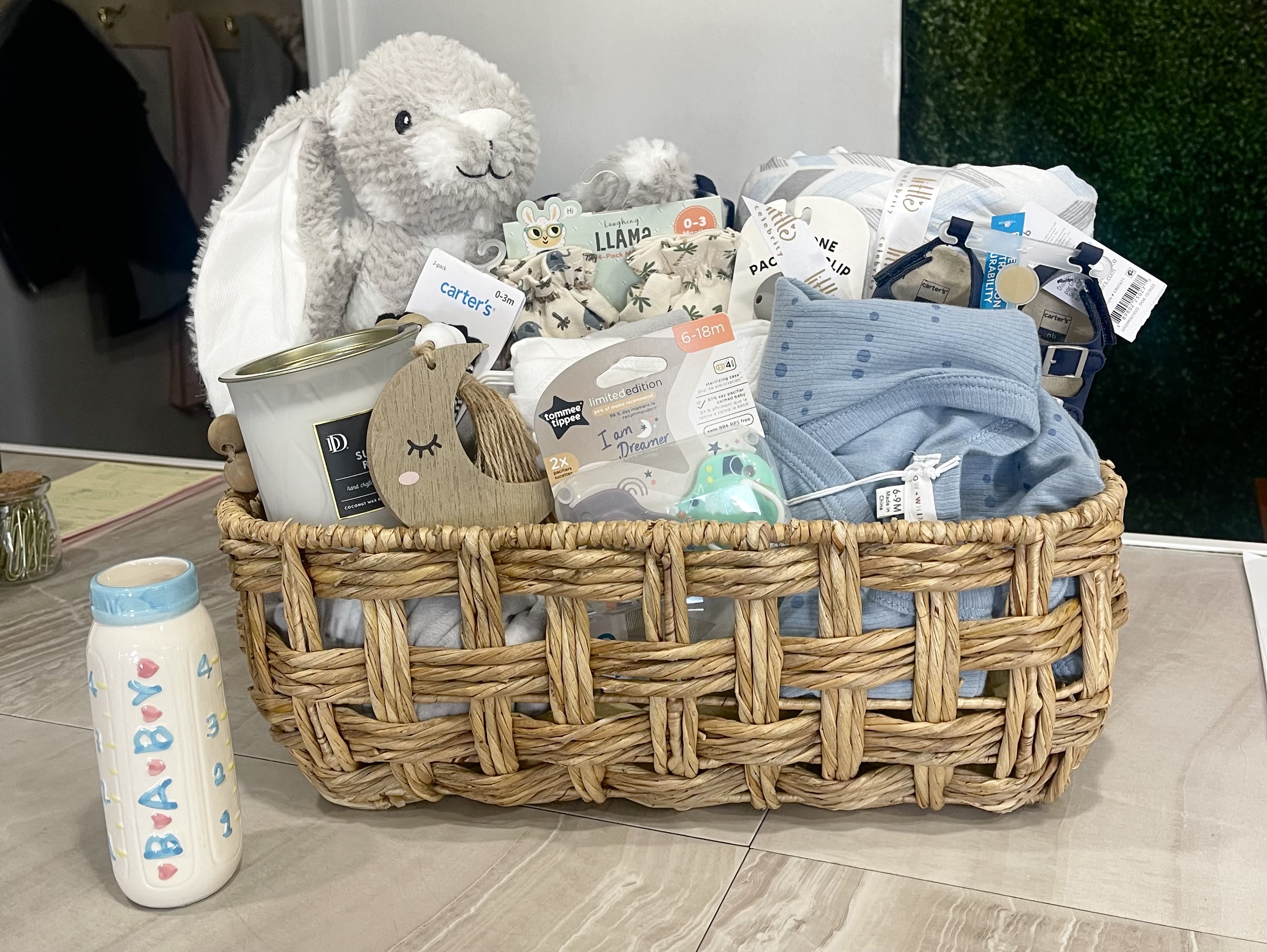 Hello Baby Boy Basket - Welcome the newest little guy home with a gift basket bursting with sweetness, snuggles, and smiles!  This ultra-adorable baby boy gift set is packed with cozy essentials for baby and a candle for the parents. From a super-soft starry blanket to a sweet plush bunny and a bottle vase that will be filled with fresh flowers this basket is the perfect way to say “Congratulations!” 