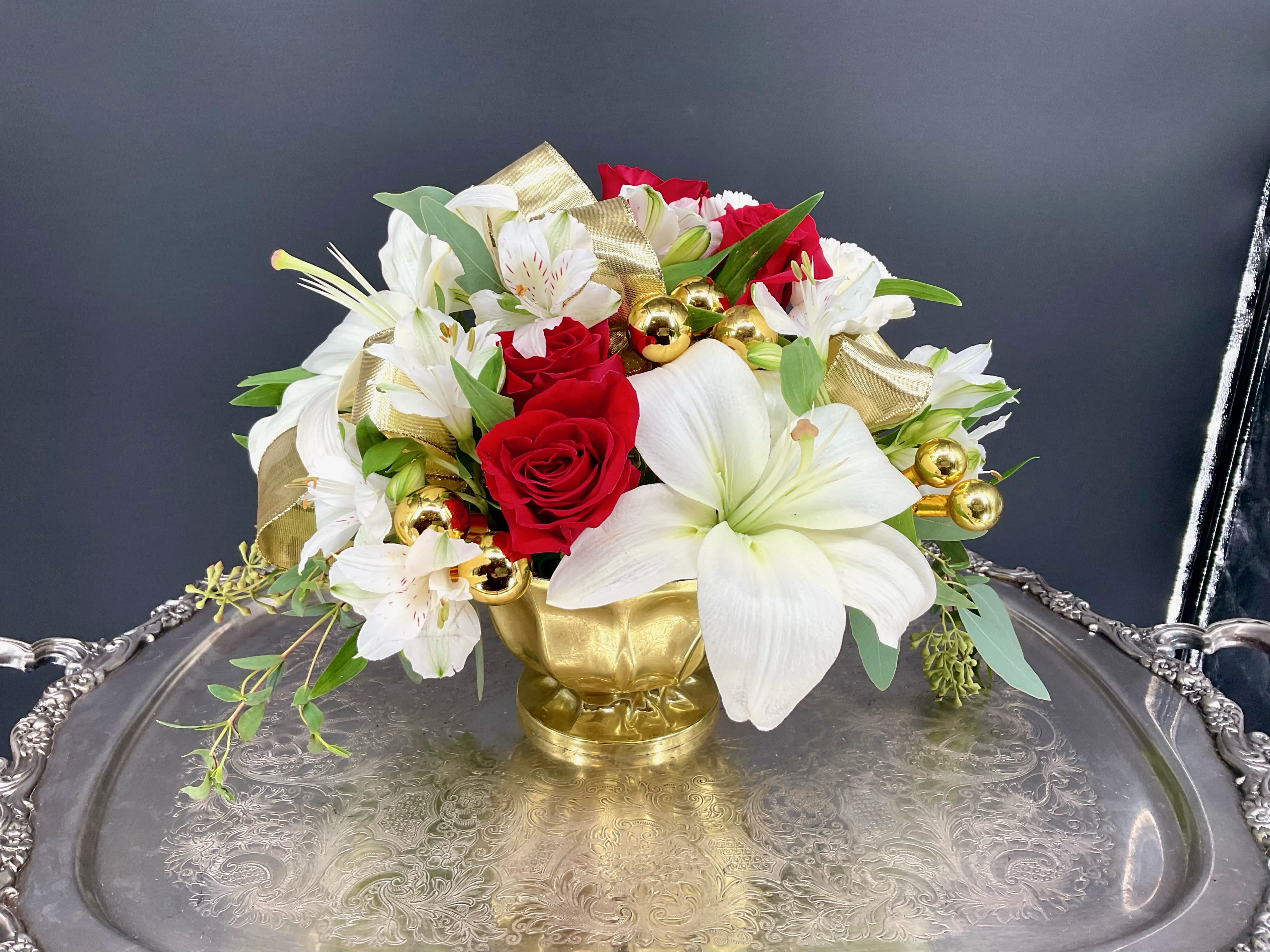 Golden Champagne - The Golden Champagne arrangement brings a golden celebration of family and friends; and this dazzling mix of red scarlet roses and fragrant white lily blossoms interwoven with golden accents and a shiny ribbon will bring a touch of joy and beauty to any gathering.  