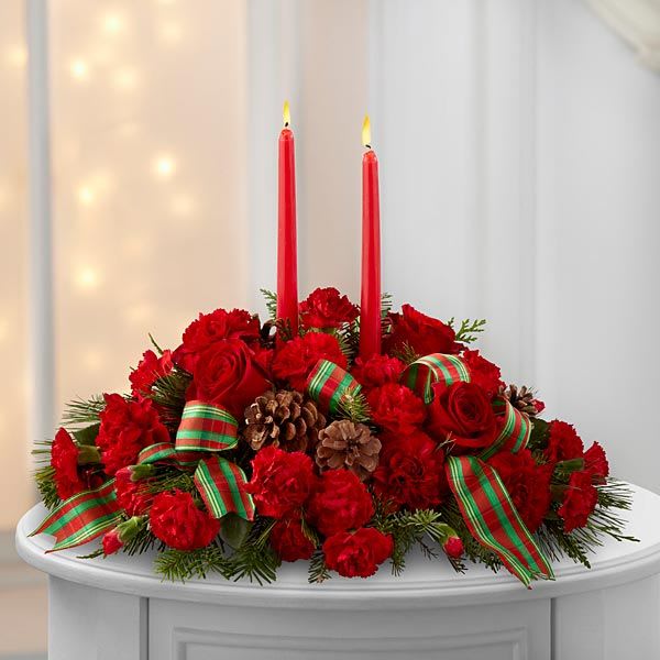 ---- HOLIDAY LOVE CENTERPIECE ----  NEW-A102 - Our HOLIDAY LOVE CENTERPIECE is the perfect floral gift for the family's Christmas  table, When you will not be able to make it home for the holidays let them know you are sending you love with this arrangment. Made of live, fresh , fragrant Christmas greens , 2 tall red candles, red roses, red carnations, holly, pine cones and accented with bright holiday ribbon. 