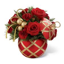 CHRISTMAS ORNAMENT ARRANGMENT  NEW-A97 - Our CHRISTMAS ORNAMENT ARRANGEMENT is made of red roses, red carnations and fragrant Christmas greens with gold ribbon accents ,  arranged in a red and gold ceramic Christmas ornament shaped candy jar with lid. This keepsake container will be a treasured part of the recepants decorations for years to come. 