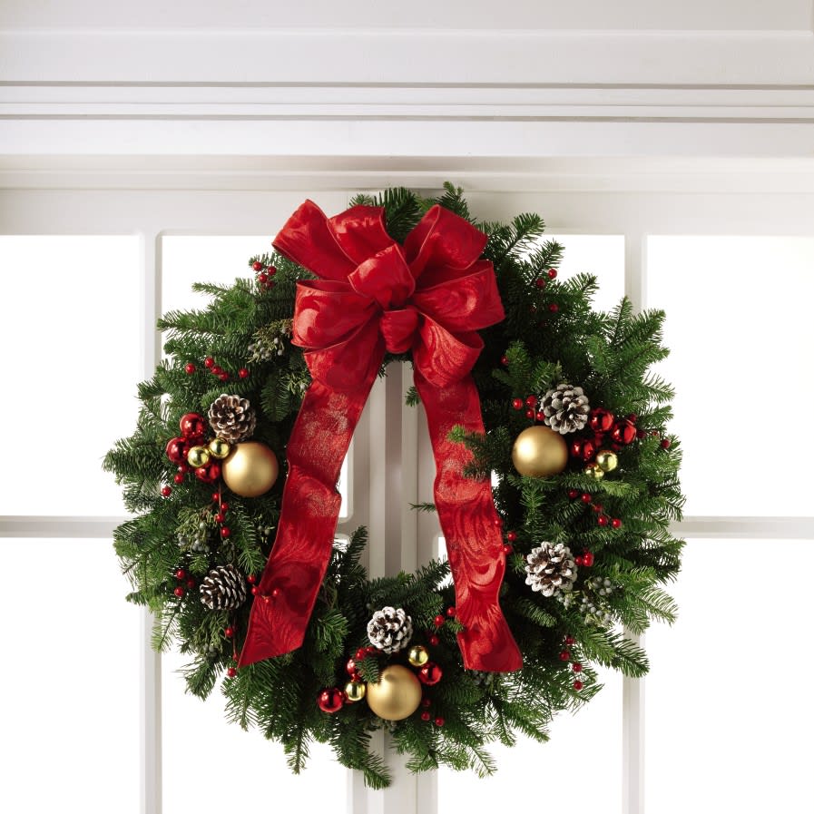 The FTD Winter Wonders Wreath - Ready to make your front door look picture perfect this Christmas season, this holiday wreath has a special sparkle to it that will bring the joy of the season to your home. With a base consisting of fresh and fragrant Christmas greens, this wreath is bedecked with white tipped pine cones, shining red and gold glass holiday balls, and clusters of berries, culminating in a standout red bow at the top. A wonderful way to deck your halls this holiday season or to send as a gift to share in your recipient's Christmas celebration. 22-inches in diameter. 