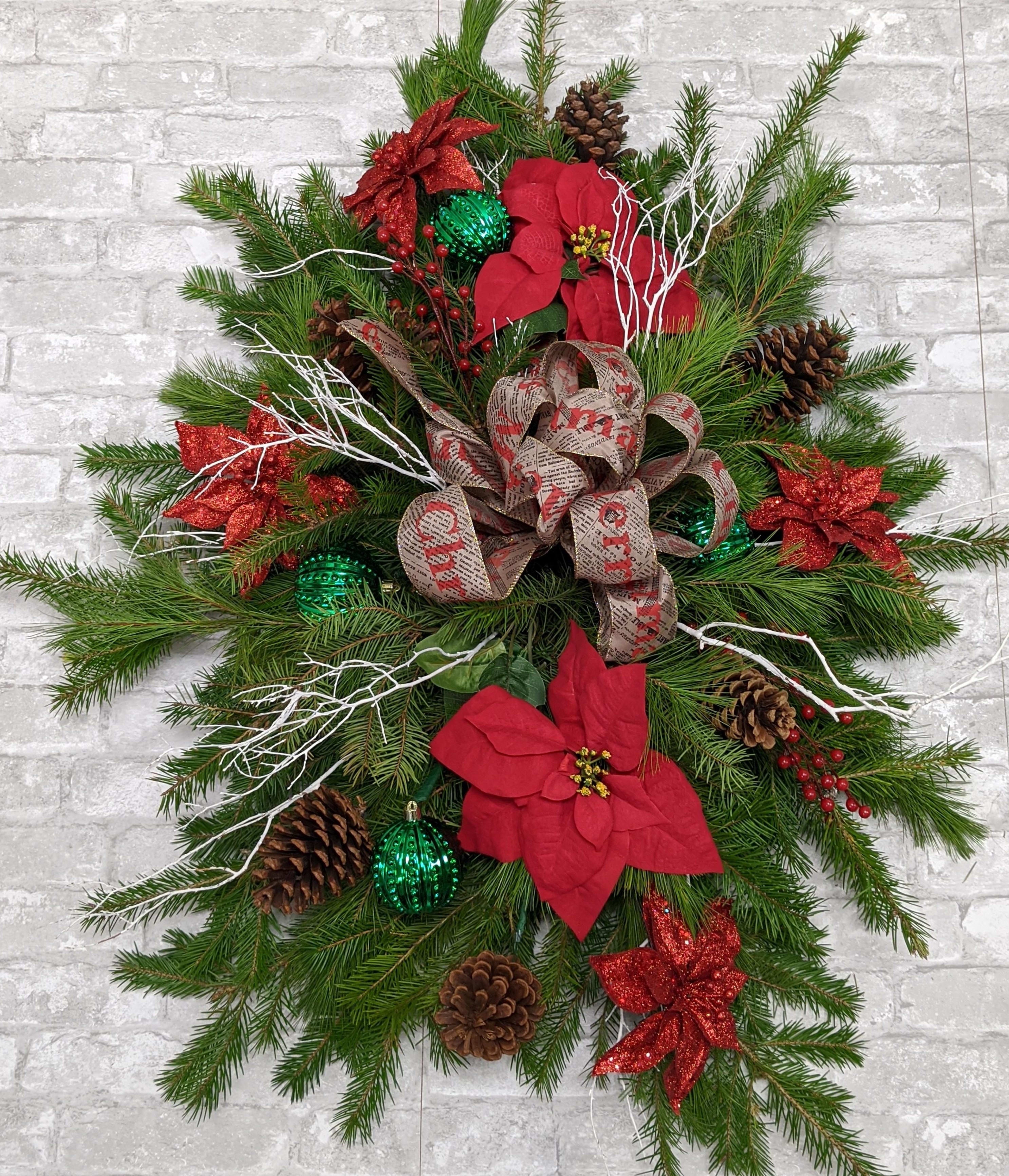 Large Grave spray - This large grave spray consists of Christmas greens, pine cones, Christmas balls, red velvet bow and frosted branches. This lovely piece can be delivered to a local cemetery or picked up at the store so you may honor your loved one personally. Approximately 36&quot; long X 24&quot; wide.