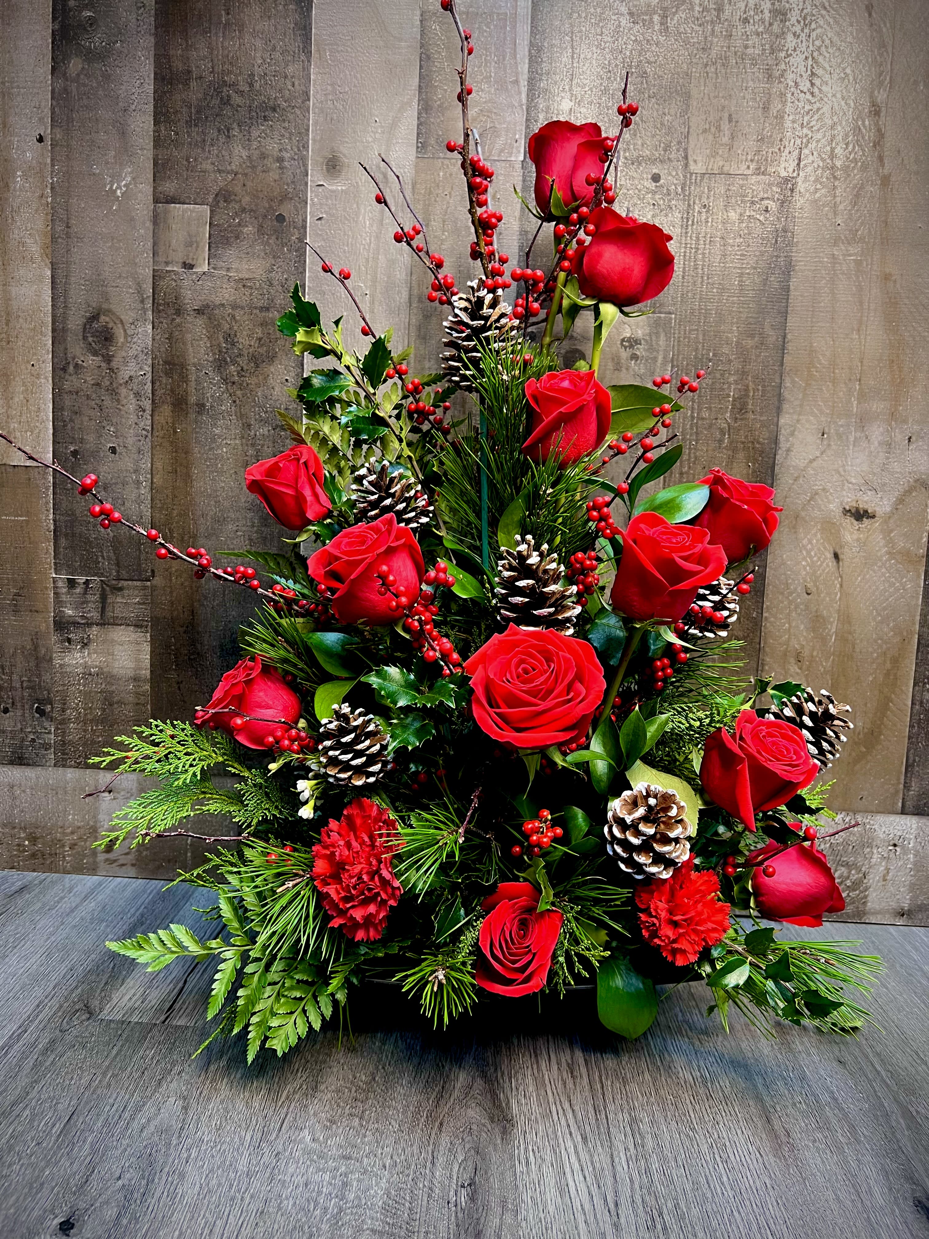 “Scarlet Splendor”  - "Experience the festive allure with our 'Scarlet Splendor' arrangement, a towering display of vibrant red roses adorned with Christmas accents. Embrace the season's enchantment as you indulge in the elegance of scarlet blooms, a true embodiment of festive splendor. Elevate your celebrations with this majestic arrangement, a perfect blend of sophistication and holiday cheer. Spread joy and make a statement with 'Scarlet Splendor' – where beauty meets the magic of Christmas." 28”h x 20”w 