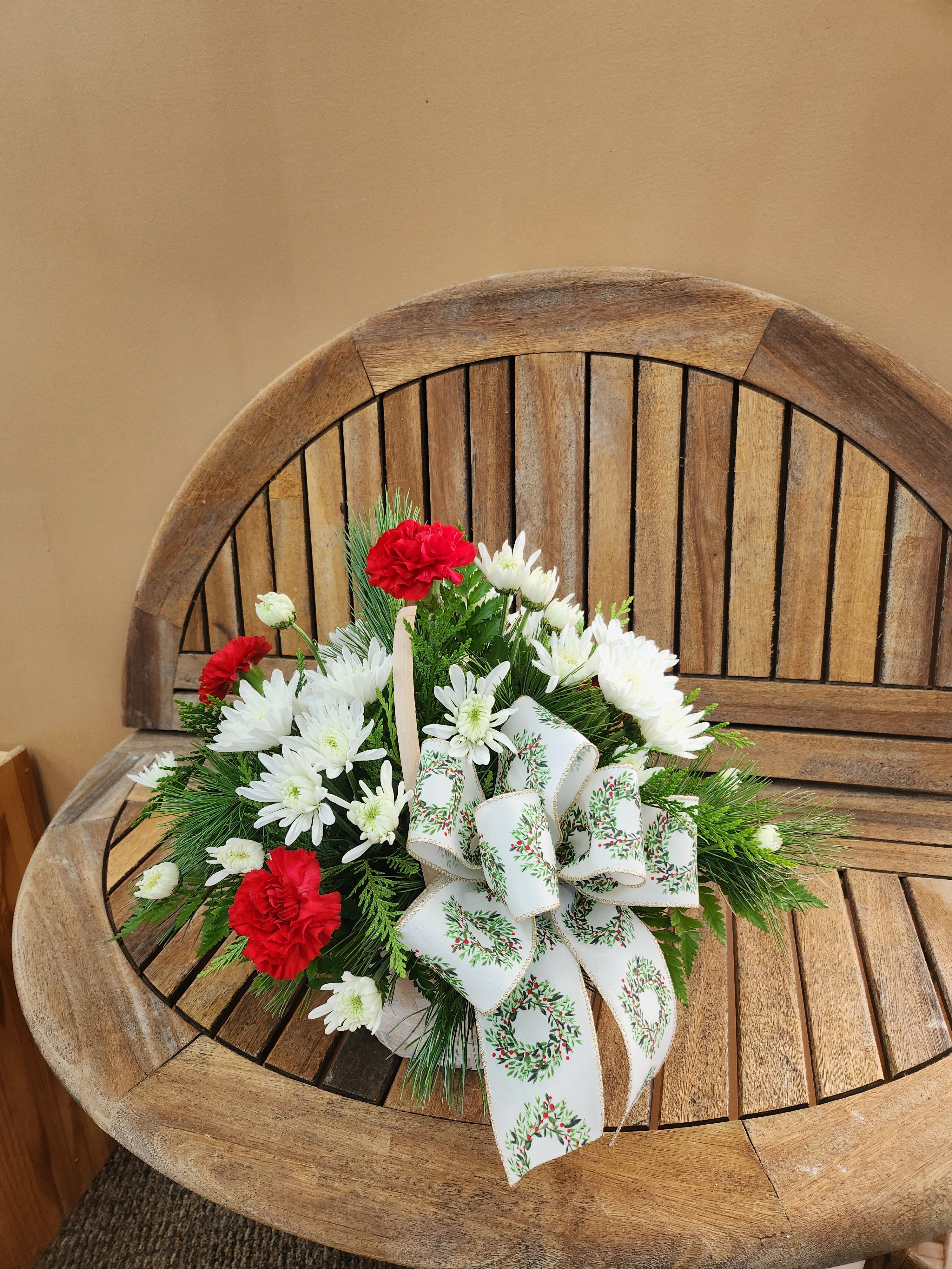 Christmas Cheer Basket - Small Basket of Christmas greens with red and white flowers and Christmas ribbon. Ribbon may vary.