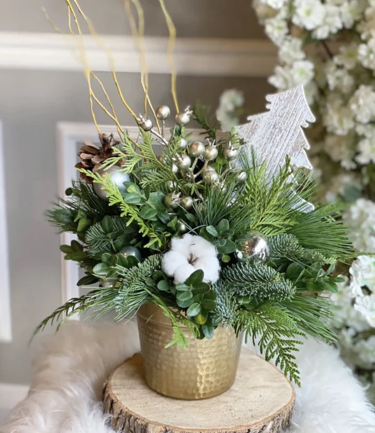 Silver Bells  - Celebrate the elegance of the season with our Silver Bells™, a chic winter design that blends modern metallic accents with timeless holiday greenery. Styled in a gold hammered vase for a touch of warmth and luxury, this arrangement features a lush collection of fresh evergreens, juniper, cedar, boxwood, natural pinecones, silver berries, cotton blooms, and a shimmering winter tree ornament for the perfect holiday highlight.  Soft textures meet festive sparkle, creating a sophisticated winter moment ideal for entry tables, office desks, corporate gifting, holiday parties, and home décor. Whether you’re elevating your seasonal décor or sending a thoughtful gift, the Silver Bells Arrangement™ brings a polished, cozy, and winter-fresh aesthetic to any space.  Crafted in Bloom In Glory’s signature style — refined, intentional, and beautifully curated.  ⸻  	•	Silver Bells floral arrangement 	•	Holiday flower arrangement Orlando 	•	Winter greenery centerpiece 	•	Christmas floral décor 	•	Pine and cedar holiday arrangement 	•	Luxury holiday flowers Orlando 	•	Metallic holiday centerpiece 	•	Corporate holiday floral gifts 	•	Bloom In Glory Christmas collection 	•	Winter tabletop arrangement 