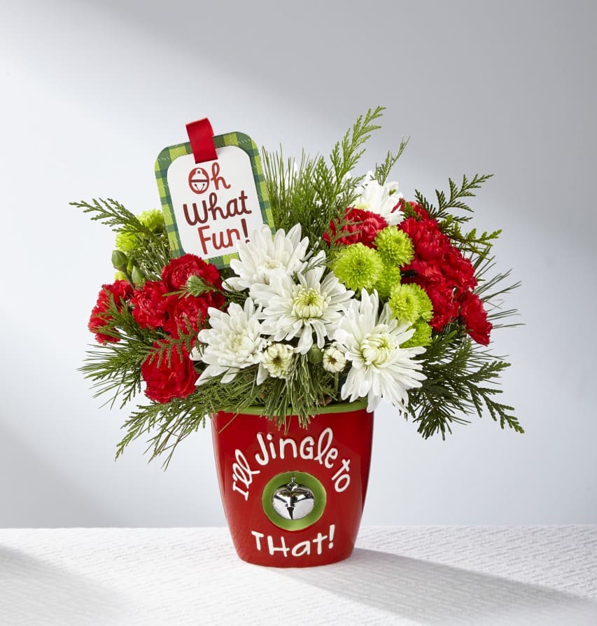 The FTD® I'll Jingle to That™ Bouquet by Hallmark - Ring in the holiday season with friends and family in yuletide style and fresh beauty with The FTD® I'll Jingle to That™ Bouquet by Hallmark! Rich red roses, red mini carnations, white chrysanthemums, green button poms, variegated holly, and fragrant holiday greens are arranged to perfection to create a winning Christmas gift. Presented in a ceramic red vase with the sentiment, "I'll Jingle to That!" in white lettering on the front and a single jingle bell hanging at the center, this fresh flower bouquet is also accented with a hand lettered keepsake Hallmark tag that reads, "XOXOXO," to create an unforgettable way to send your merriest wishes near and far this Christmas season. 