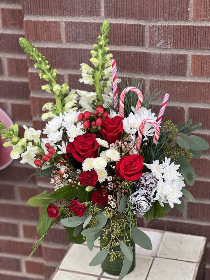 Festive Pines - Bursting with Christmas spirit, this lush rose bouquet is accented with candy canes and pine cones for a touch of festive fun.
