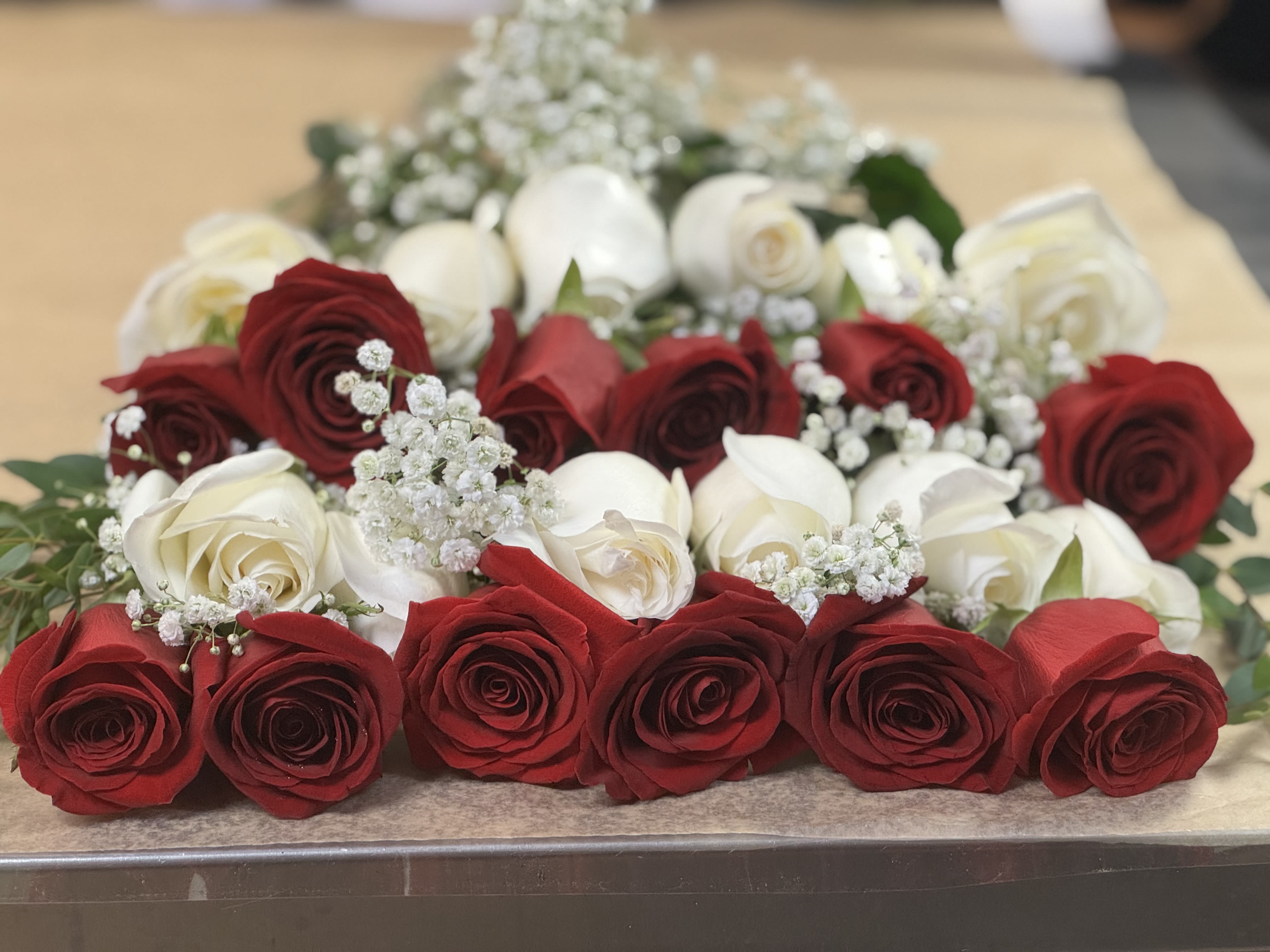 Presentation bouquet: 18 red and white roses - 18 red and white long stem roses prepared presentation style with greens, filler and a bow.