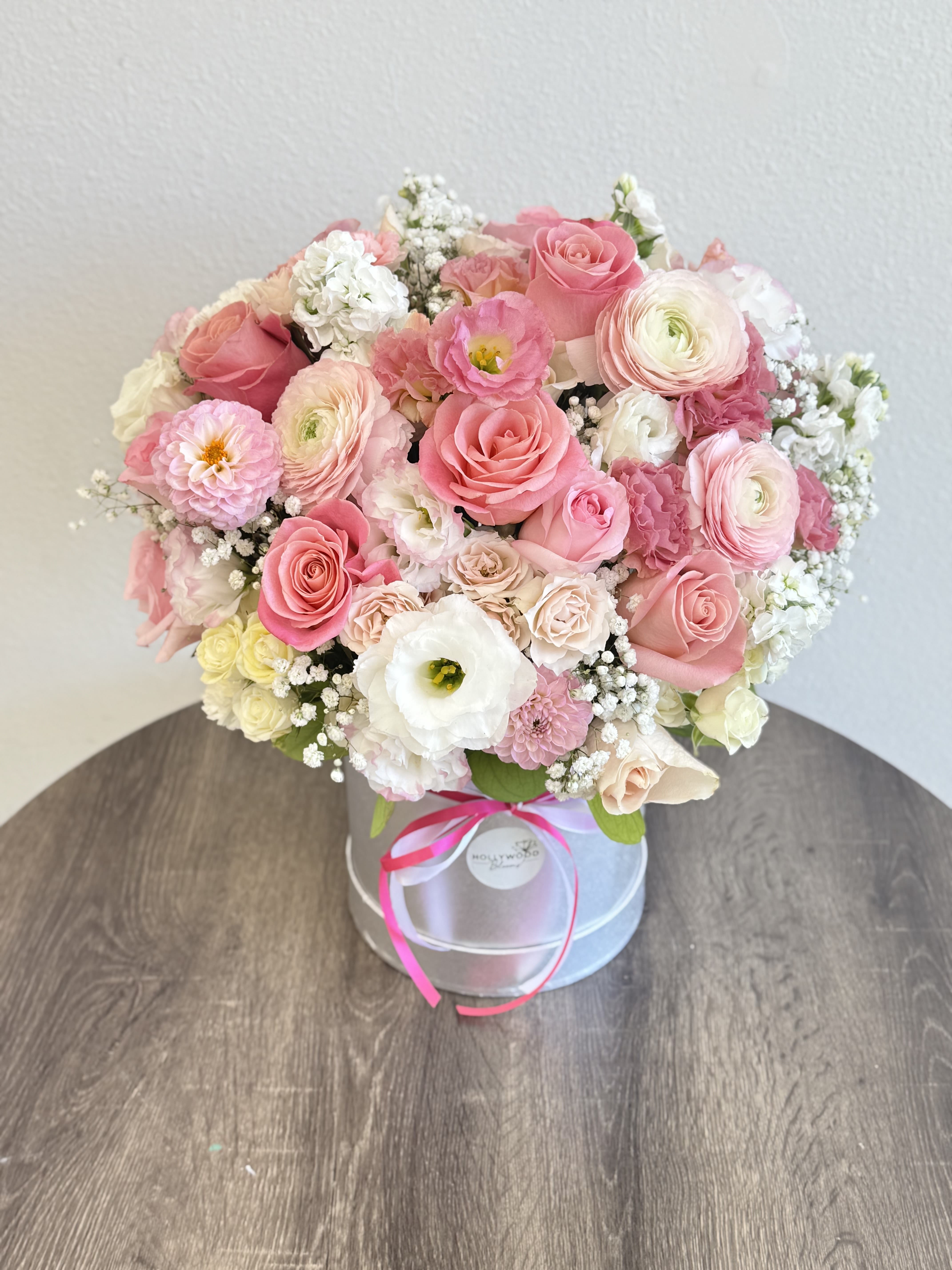 Blushing Petals -  Blushing Petals is the perfect expression of softness and romance. This luxurious flower box features delicate shades of pink, white, and cream — with lush ranunculus, garden roses, lisianthus, and other seasonal blooms artfully arranged by hand.  Whether you’re celebrating a birthday, anniversary, baby shower, or simply want to brighten someone’s day, this bouquet adds elegance and joy to any moment. Beautifully presented in a designer hat box and tied with ribbon, it’s available for same-day delivery across Los Angeles.  Send love and beauty with Blushing Petals — a gift to remember.
