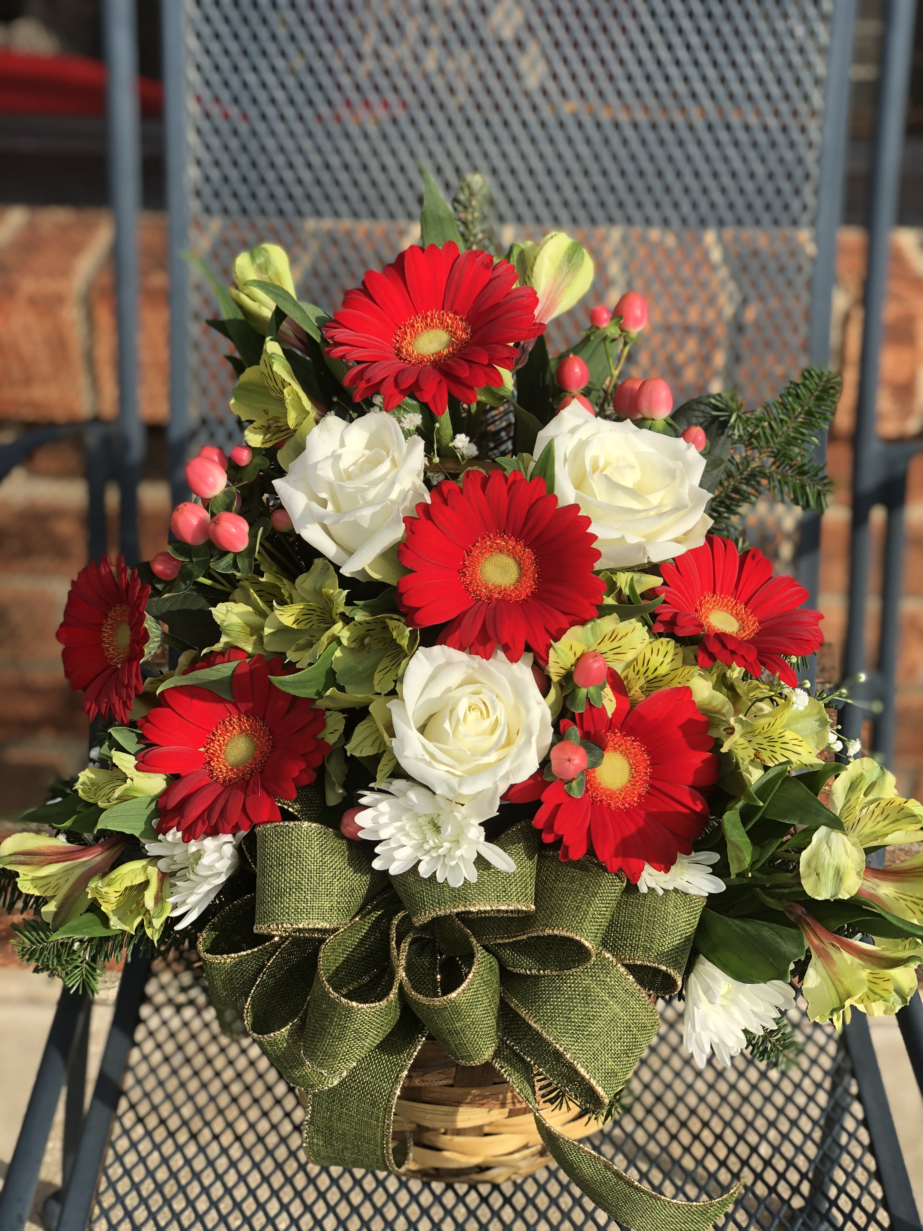 Daisys In The Snow - This arrangement will warm the heart of anyone during the cold winter months of New Jersey, cute miniature gerbera daisies mixed with alstromeriae and berries sit amongst a mix of holiday greens in one of our many containers - colors and containers may vary but we will still create the same warm feeling to please the recipient - one sided arrangement  