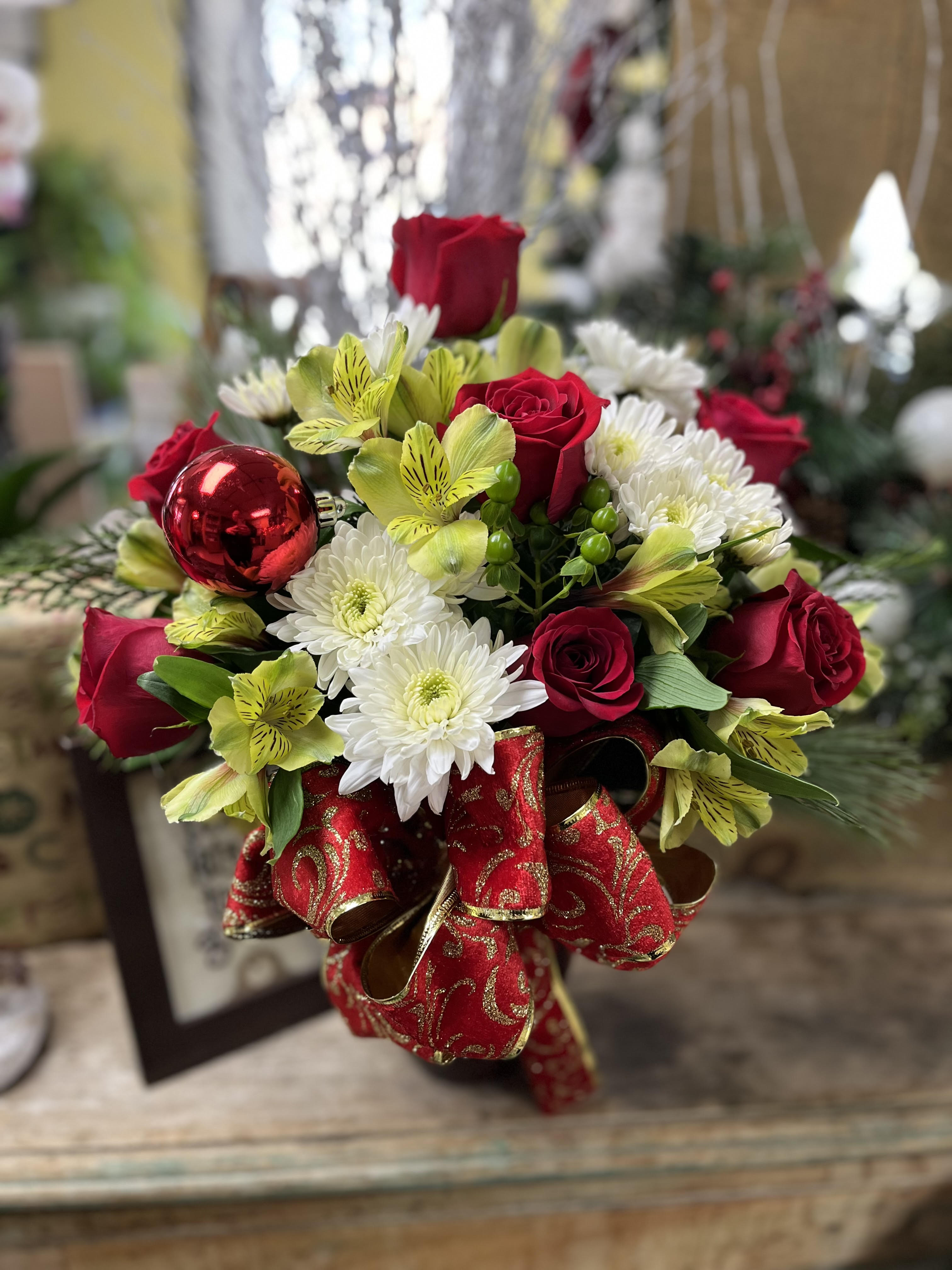 Merry and Bright - Make someone merry with a beautiful bouquet of roses, carnations and alstromariea -  this one sided arrangement makes adds holiday cheer to any room - embellishments may vary
