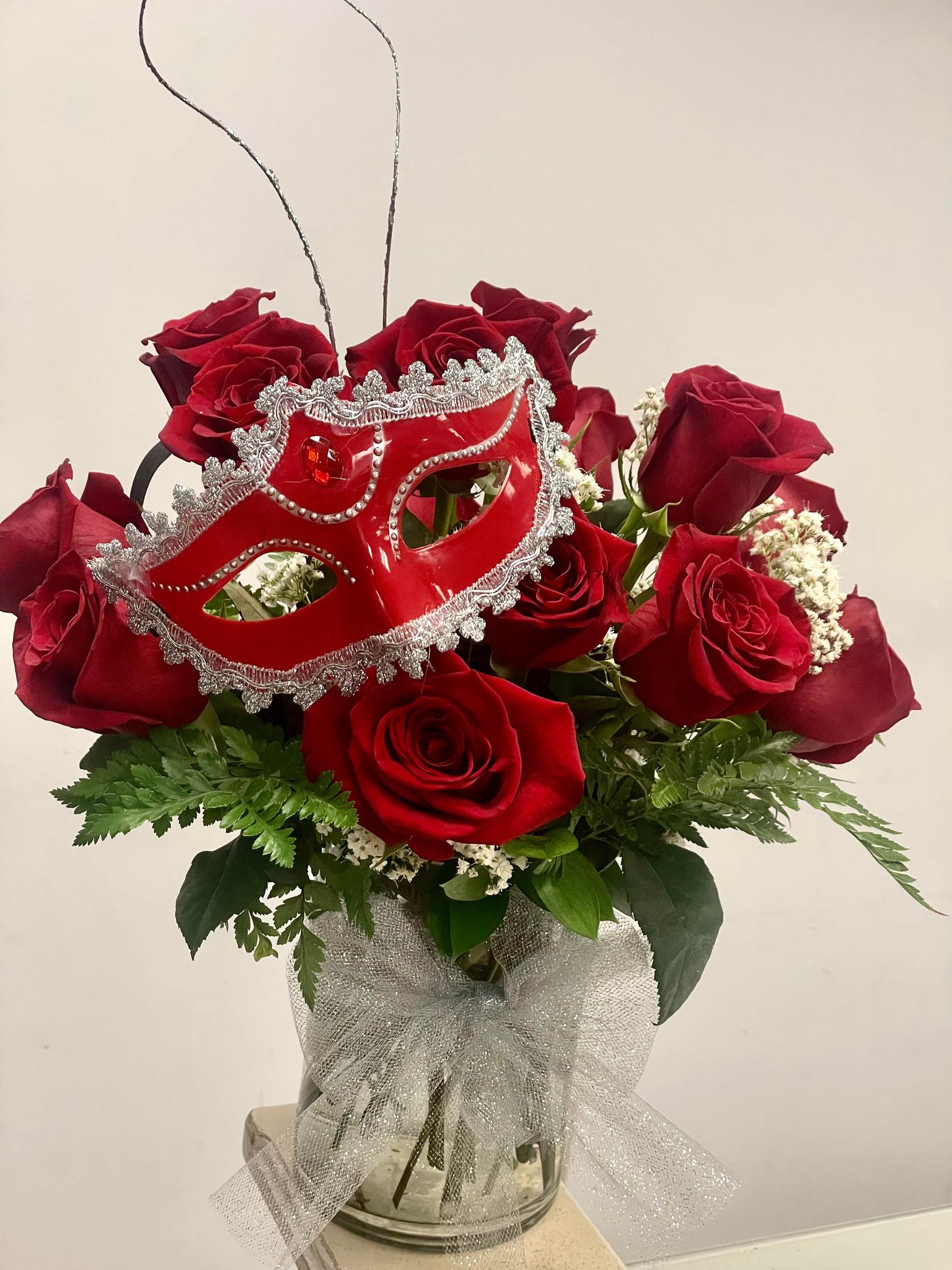 Crimson Elegance Masquerade - Whether as a gift for a loved one, a centerpiece for a special occasion, or a luxurious treat for yourself, the &quot;Crimson Elegance Masquerade&quot; is a testament to the beauty that blooms when passion and artistry intertwine. Bring this enchanting arrangement into your life and let it be a symbol of joy, love, and the magic that flowers can create.