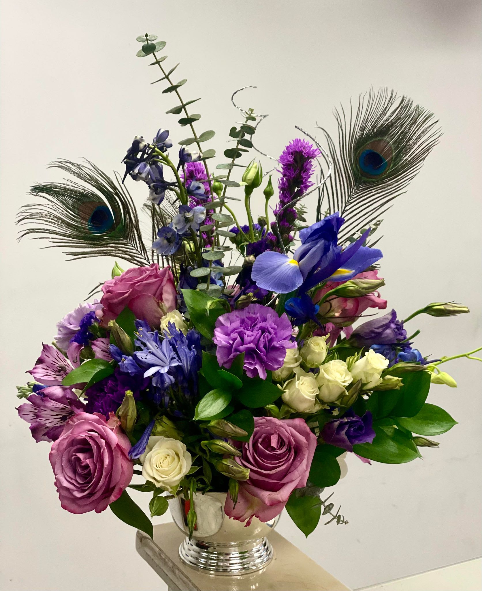 Peacock Elegance - Elevate their New Year with a gift that combines the freshness of flowers, the allure of peacock feathers, and the shimmer of silver curly willow. Order now and let the festivities bloom! 