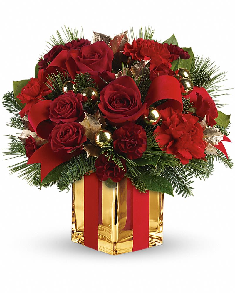 All Wrapped Up Bouquet - Lush red roses, fresh winter greens and a festive, gold mirrored glass cube are all wrapped up with red ribbon for an elegant, unforgettable gift! This bouquet of deep red roses and spray roses, red carnations, maroon miniature carnations, green holly, noble fir, white pine and lemon leaf is dressed up with red velveteen ribbon and gold ornament balls. Delivered in a stunning gold Mirrored Cube vase.Approximately 12 1/4&quot; W x 11 3/4&quot; H