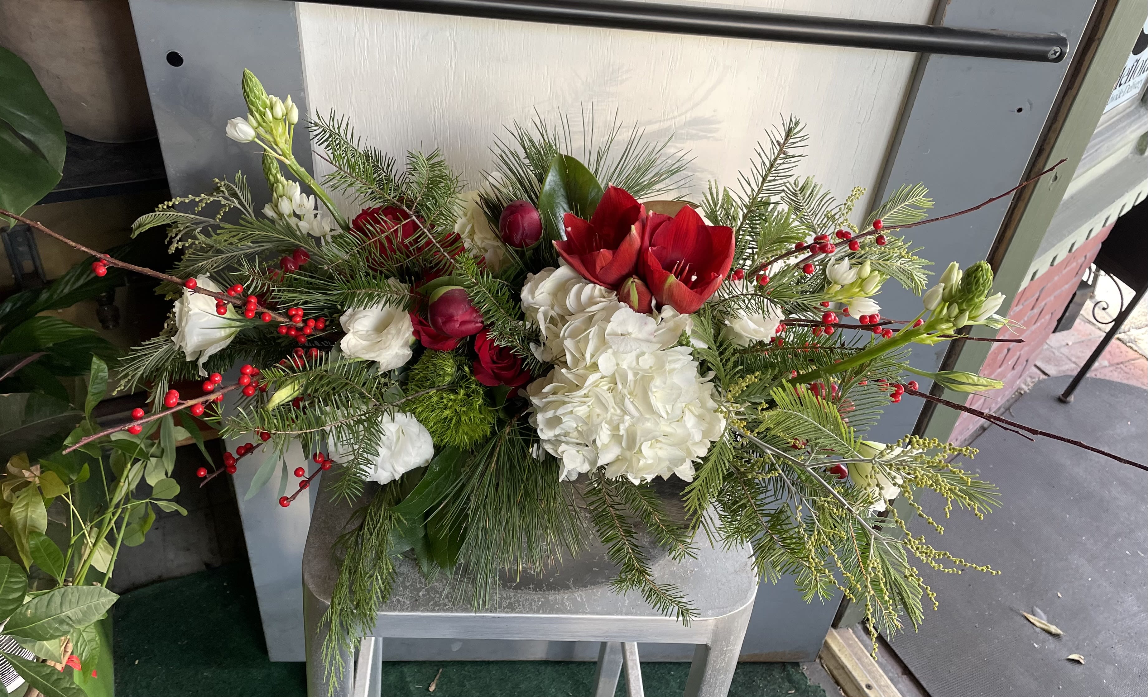 Seasonal Centerpiece #3 - Short and low centerpiece with red, white flowers and seasonal greeneries. 