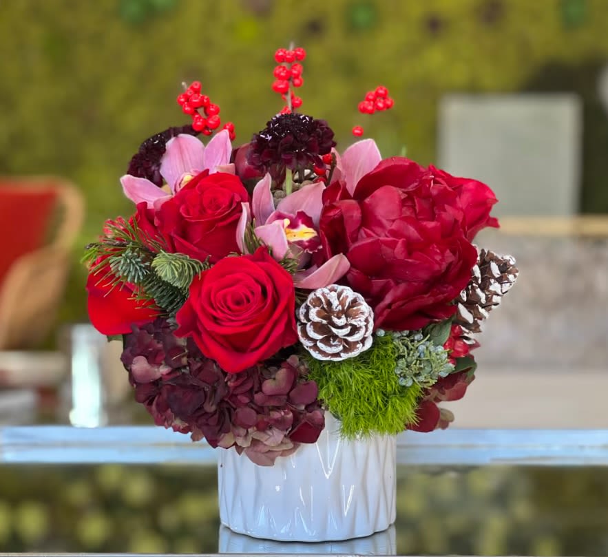 Happy Cheerful Holiday Bouquet  - Lovely bouquet of roses, hydrangea and orchids and holiday ornaments in white ceramic vase  
