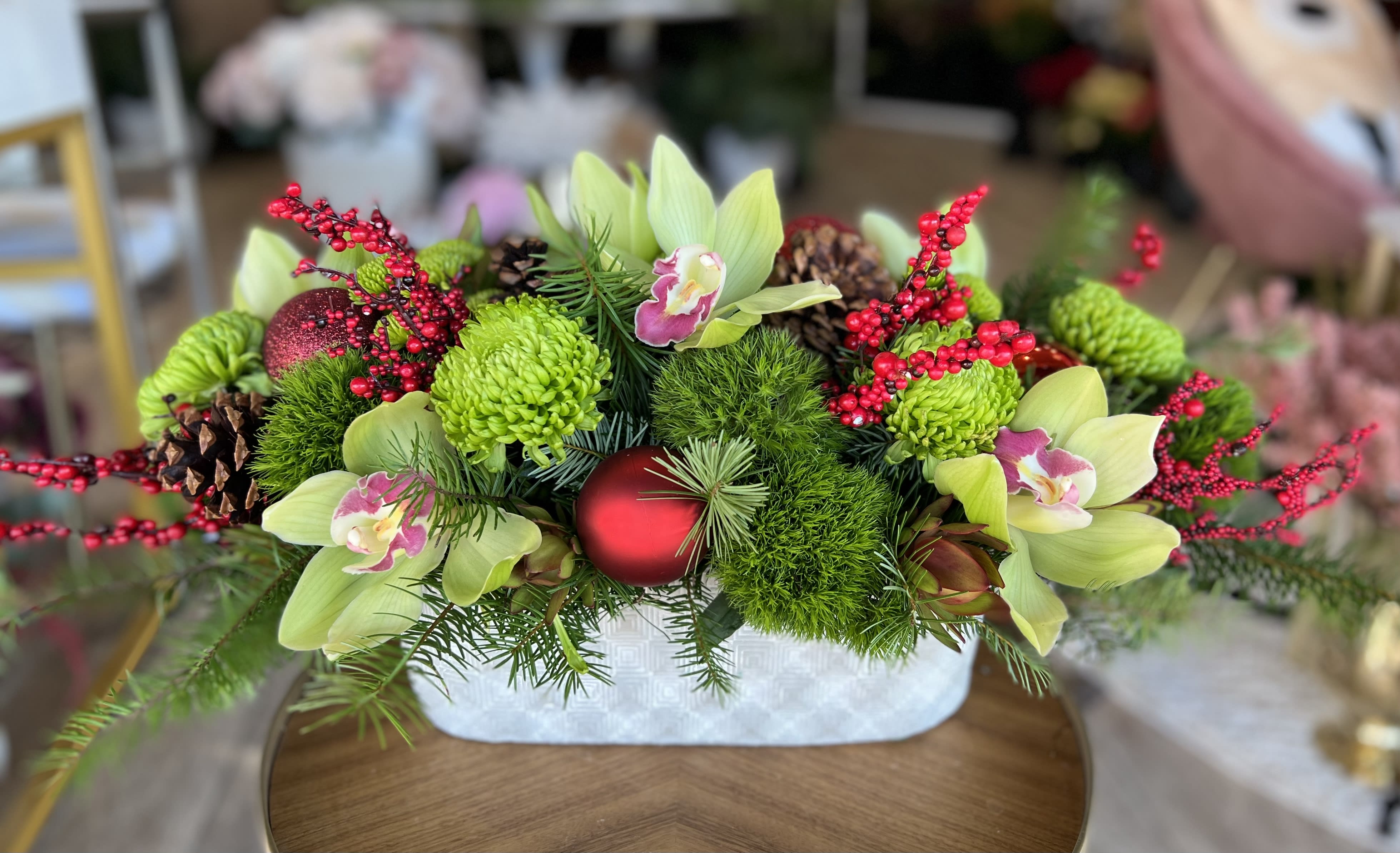 Holiday Blooms  - Gorgeous green and red centerpiece arrangement in modern vase vase 