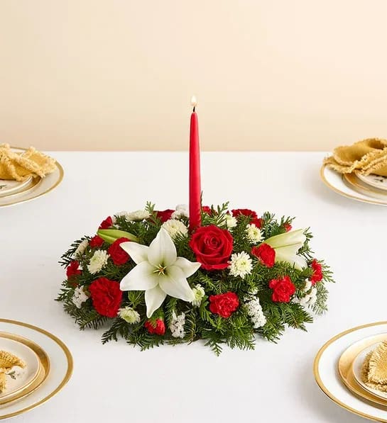 Traditional Holiday Centerpiece - Our classic table arrangement is an idyllic centerpiece for your Holiday celebration. Beautifully designed with long-lasting blooms in seasonal colors, this fragrant gathering features red taper candles to cast a warm, inviting glow throughout the holidays.