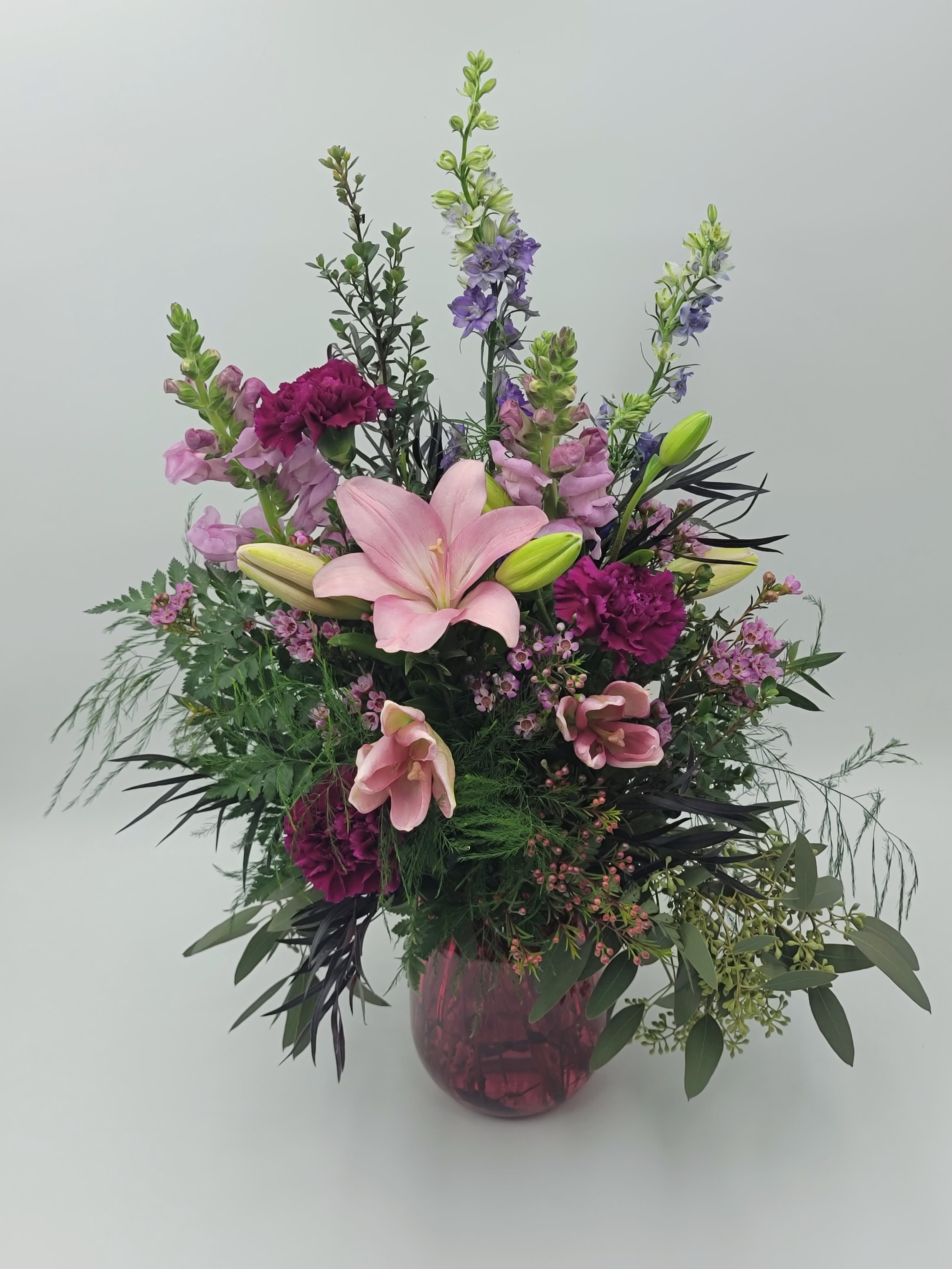 Wildberry - Select this arrangement of snapdragons, carnations, asiatic lilies and larkspur in a pink vase.