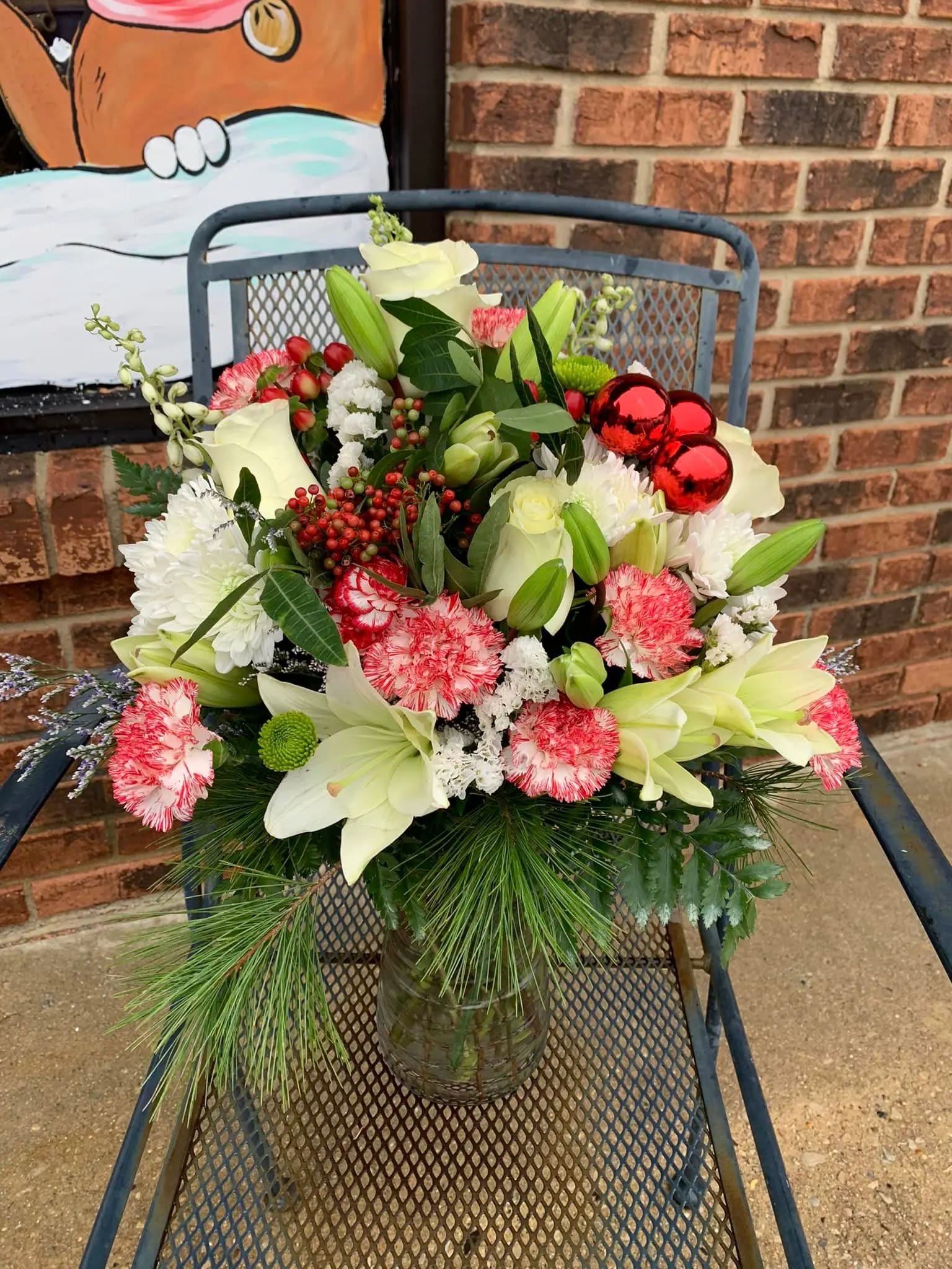 Mistletoe Kisses - When you cant be there to smooch under the mistletoe. you can still share the holiday magic, with this beautiful bouquet from Miss Bee Haven which offers an array of holiday colors, flowers and decorations.  a front sided arrangement - colors may vary 