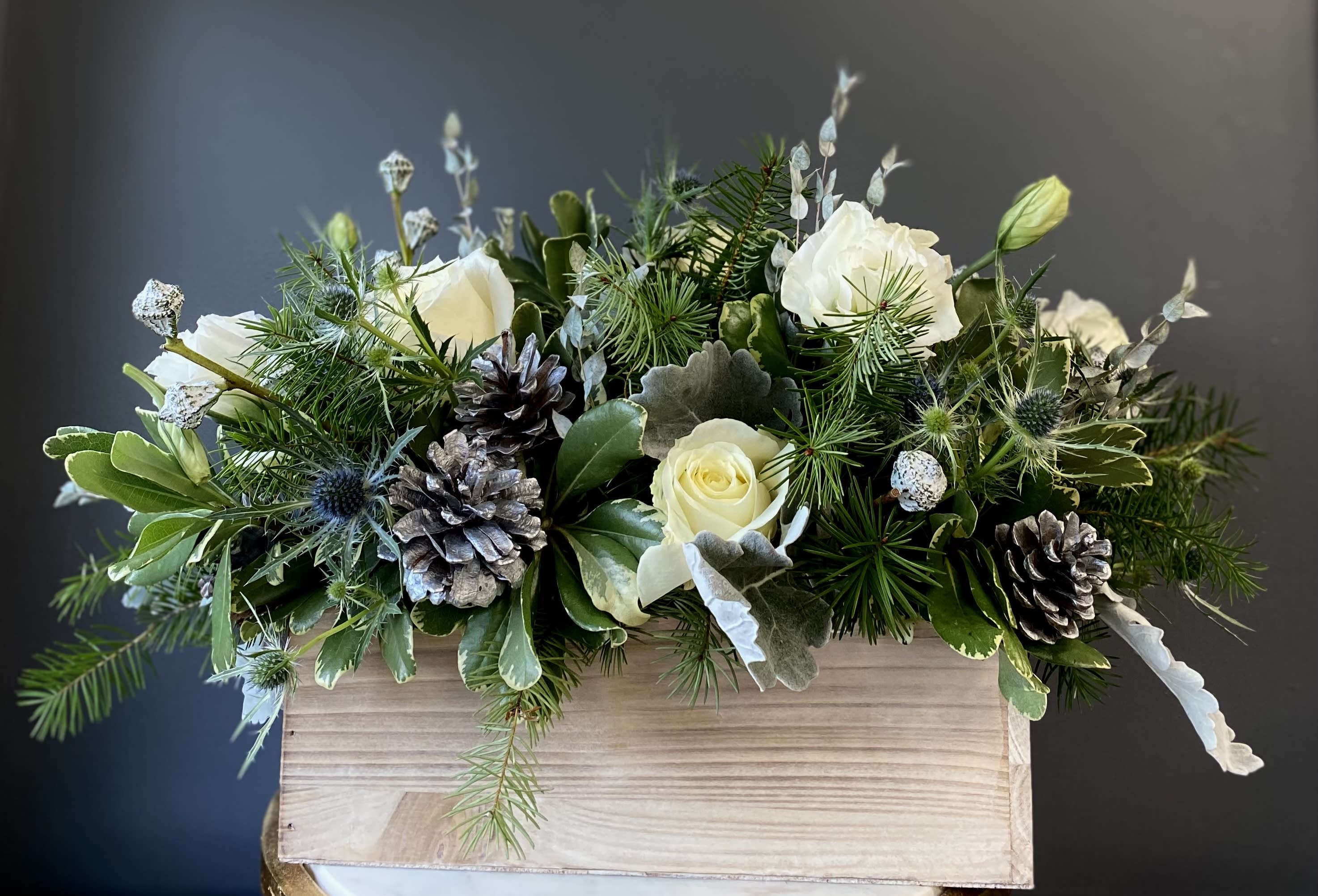 Love and Light - Bring some light and joy into your home during this holiday season with this beautiful arrangement inspired by frosty mornings and a classic color palette. With the best winter greens, long-lasting blooms, and beautiful texture from pinecones and preserved elements; this arrangement is the best way to ring in the cold months.  Don't forget to add on one of our lovely holiday candles! Warm Wishes, Autumn Leaves, Happy Chanukah!, Ugly Sweater, Secret Santa or Scarf &amp; Mittens!