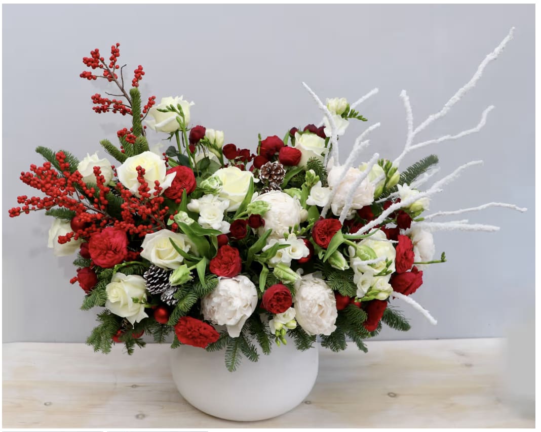 'Tis The Season  - This large arrangement is a holiday show stopper! It's made with gorgeous garden roses, peonies, and seasonal greens, berries, and branches. The standard size is approximately 2' x 2'.