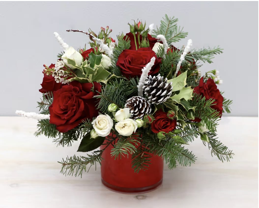 Holiday Joy - WeHo  - Don't miss out this holiday season with this festive arrangement. We've paired together beautiful red roses with white spray rose for a Christmas themed look. Seasonal greenery and pinecones make it the perfect gift for the holidays. The photo shown is in the standard size, be sure to upgrade for more blooms!