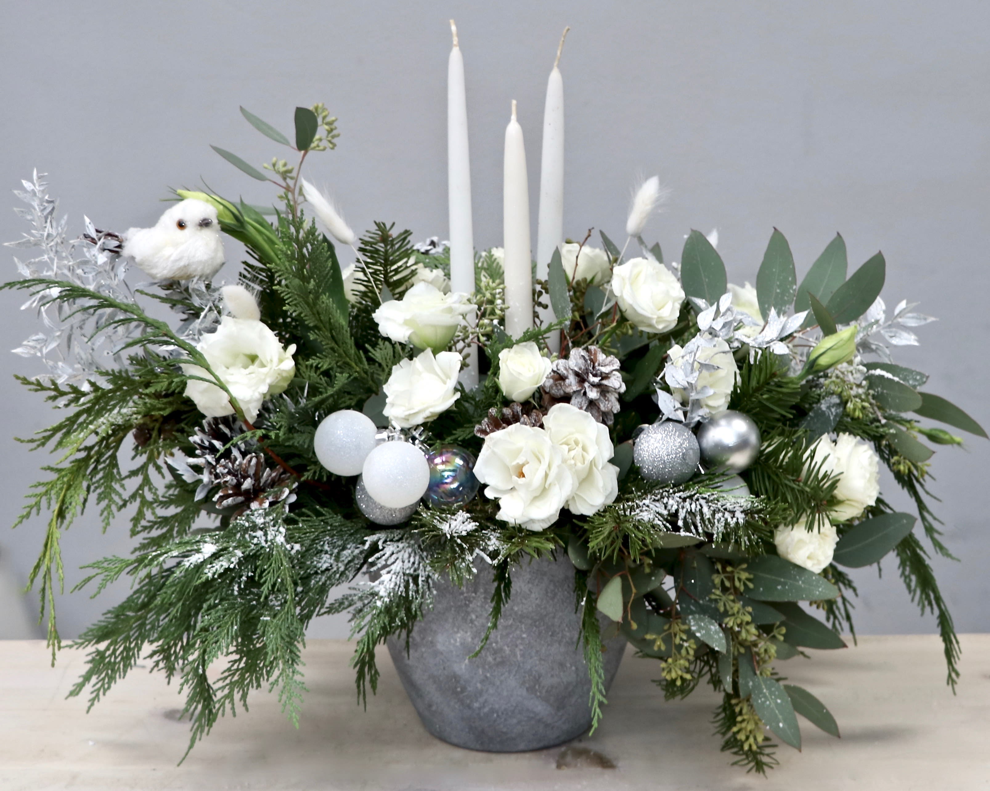 Morning Frost - West Hollywood Flowers  - This mix of white florals, seasonal greenery, and holiday accents is simple and sweet. It stands at approximately 14-16 inches tall.  