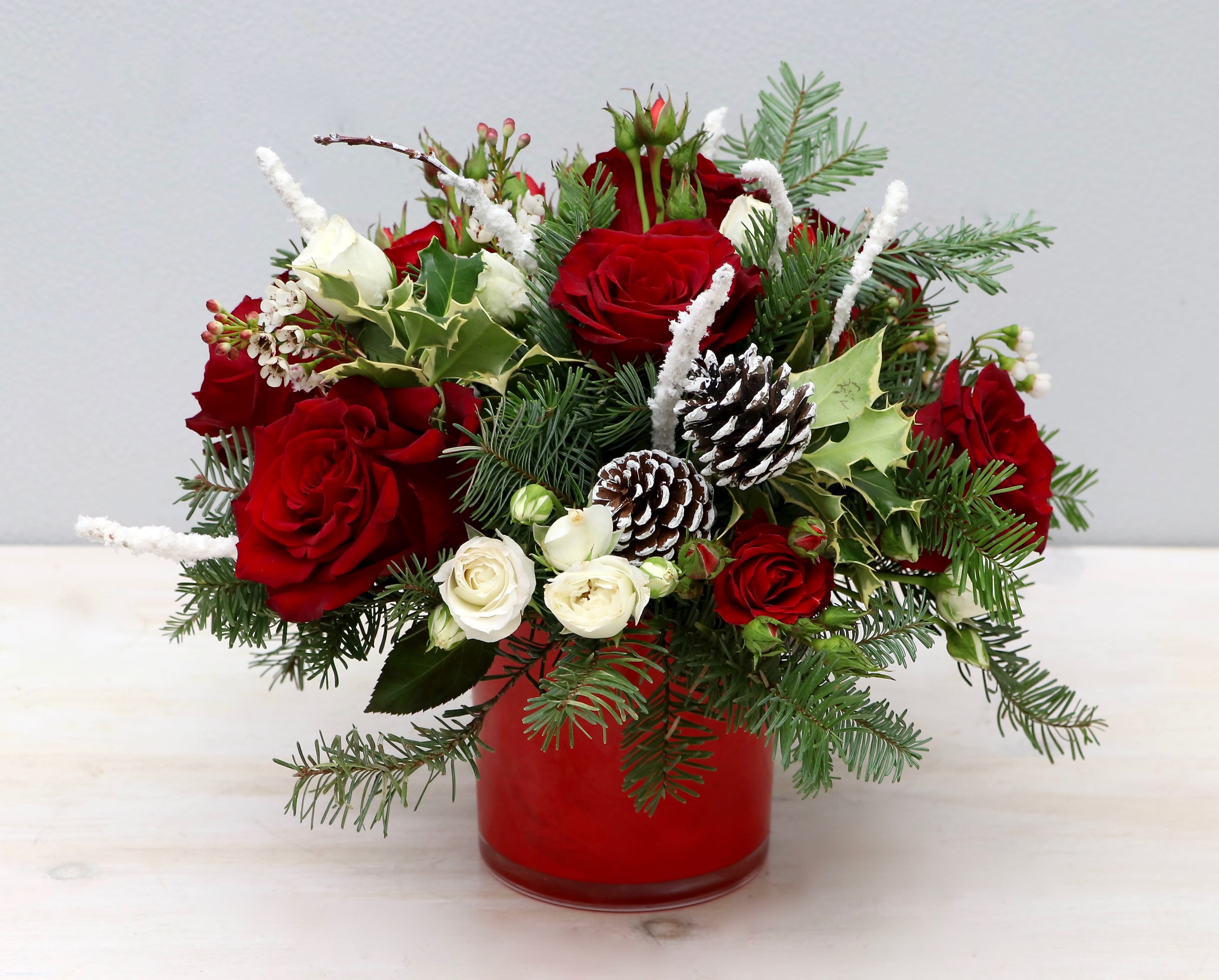 Holiday Joy - My Glendale Florist  - Don't miss out this holiday season with this festive arrangement. We've paired together beautiful red roses with white spray rose for a Christmas themed look. Seasonal greenery and pinecones make it the perfect gift for the holidays. The photo shown is in the standard size, be sure to upgrade for more blooms! 