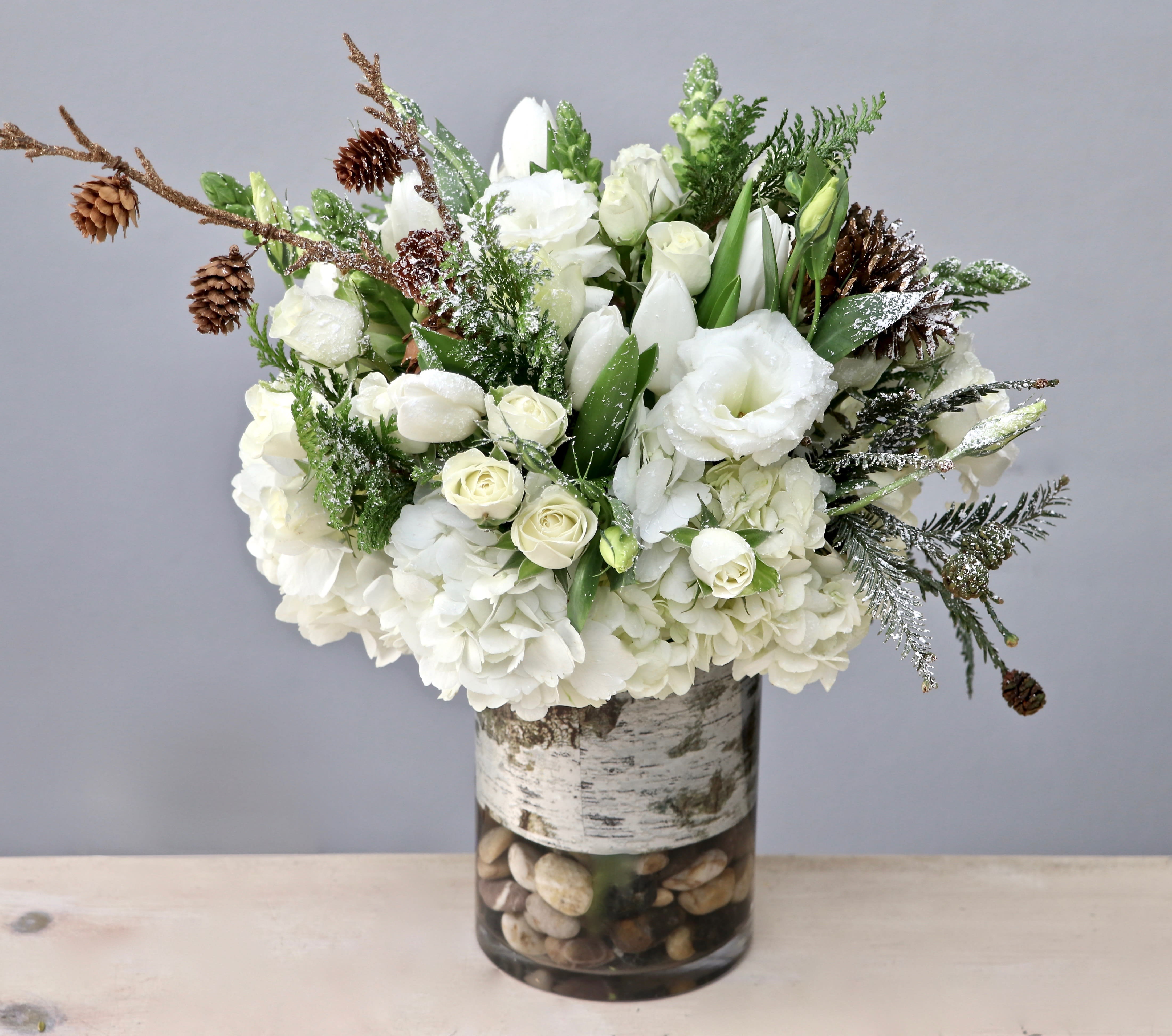 White Christmas - Glendale Florist - Complete your Christmas decor with an arrangement like this; that includes pinecones, snapdragons, and tulips. All arranged in a 5'' glass vase and standing approximately 10-12 inches tall overall. 