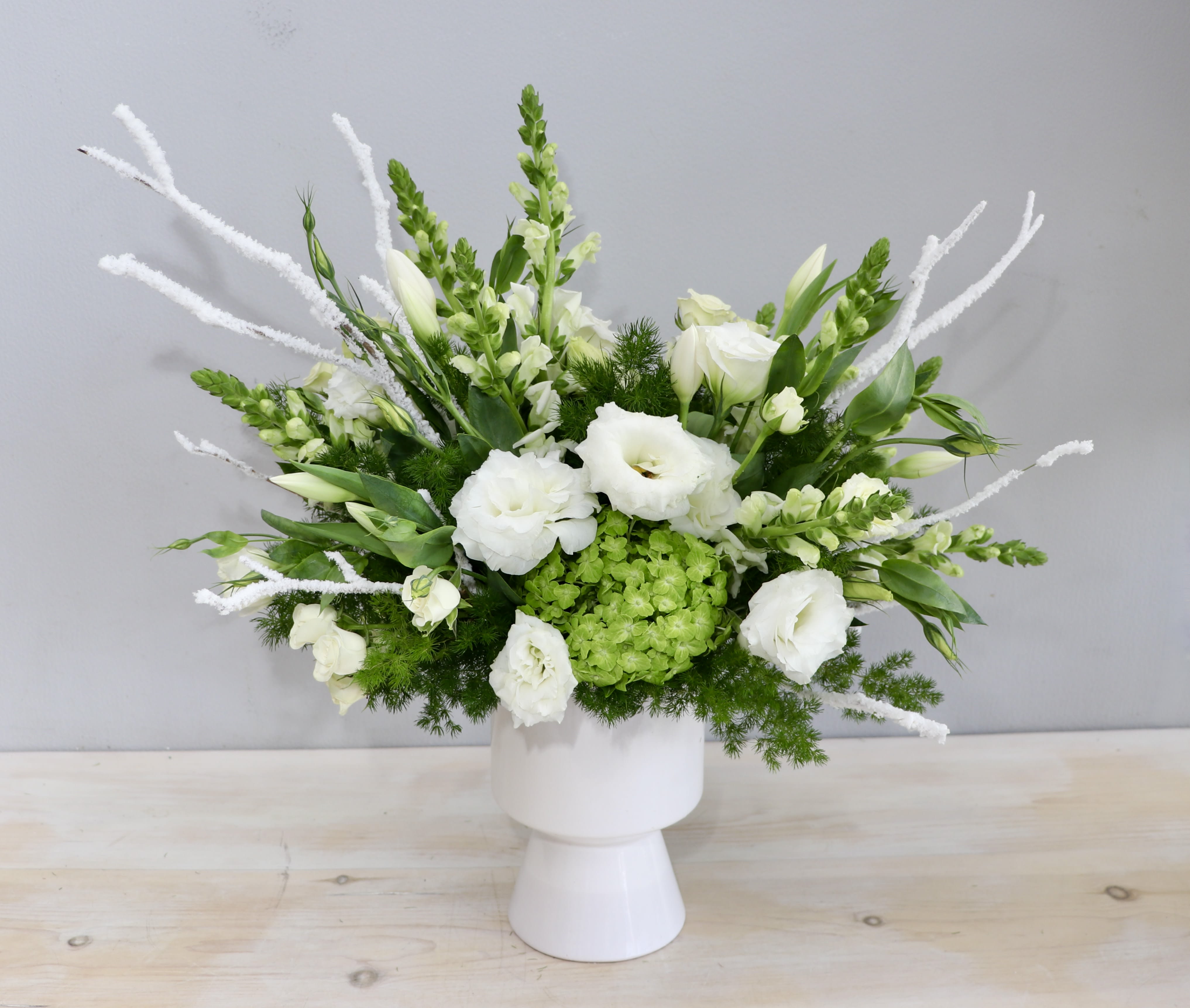 Winter Sun - Glendale Florist -  The &quot;Winter White Arrangement&quot; is a serene and enchanting floral masterpiece that embodies the tranquility and purity of the winter season. Carefully selected florals such as lisanthus, tulips and snapdragons are just a few to name. 