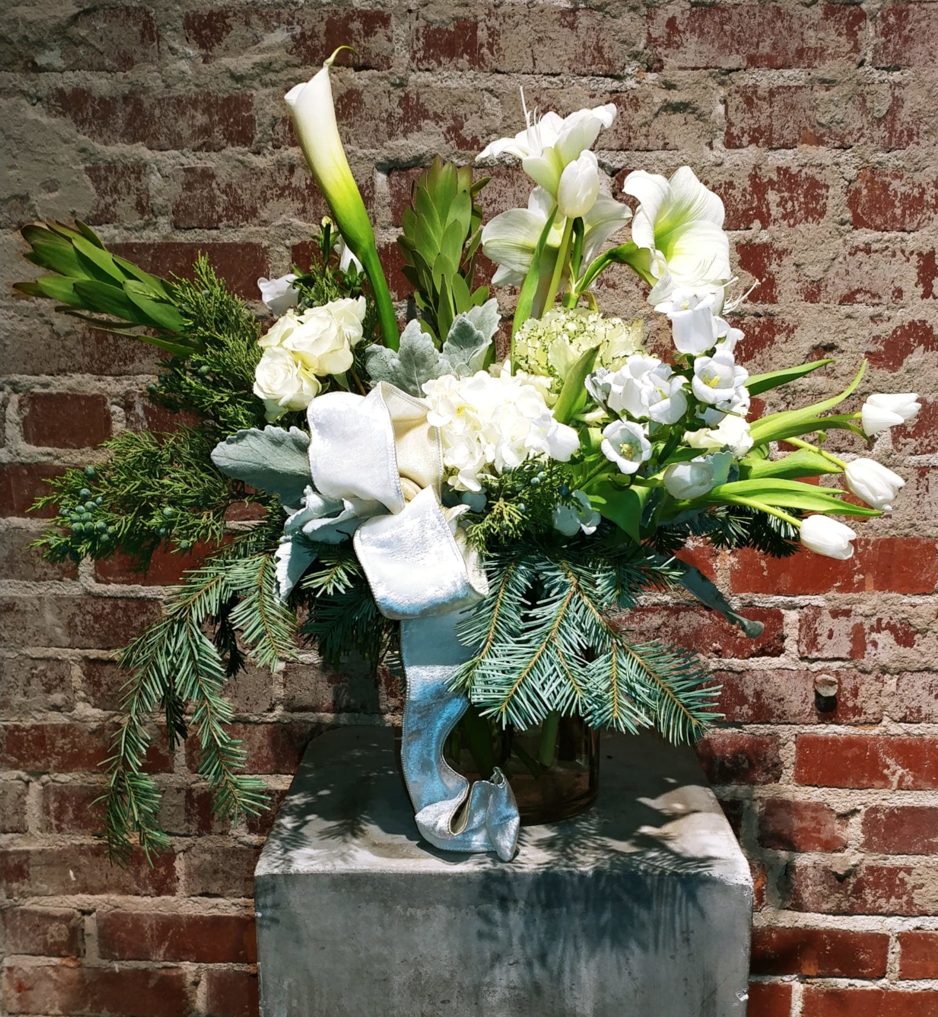 Winter Wonderland - Beautiful medley of seasonal white blossoms paired with a variety of evergreen boughs. The perfect holiday statement piece.