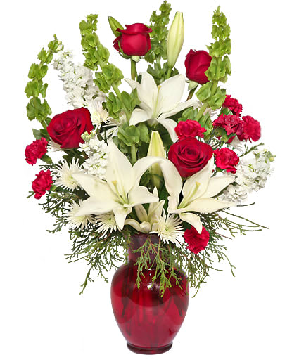 CLASSICAL CHRISTMAS FLORAL ARRANGEMENT -  Classic holiday flowers with a twist of spunky cheer perfectly describes the Classical Christmas arrangement! With seasonal evergreens, red roses, white Asiatic lilies, bells of Ireland, and more, this breathtaking bouquet is sure to bring the holiday spirit to any room