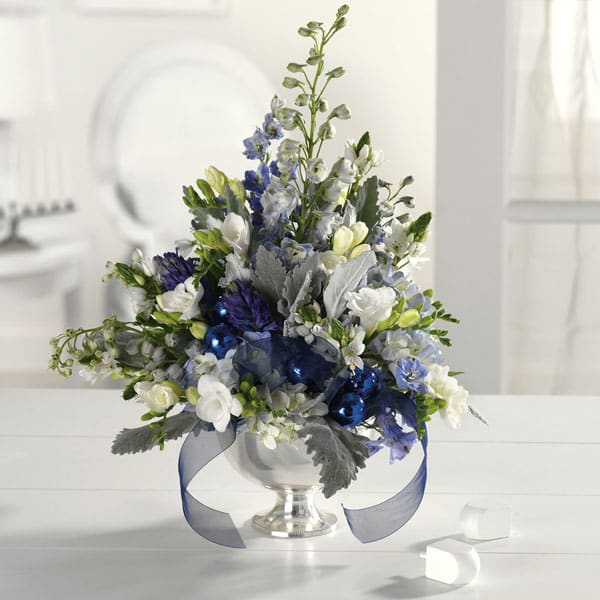 Holiday Blue &amp; Silver - Icy blues, winter whites and silvery greys come together in a footed bowl. May include freesia, delphinium, dusty miller with holiday accents and ribbons