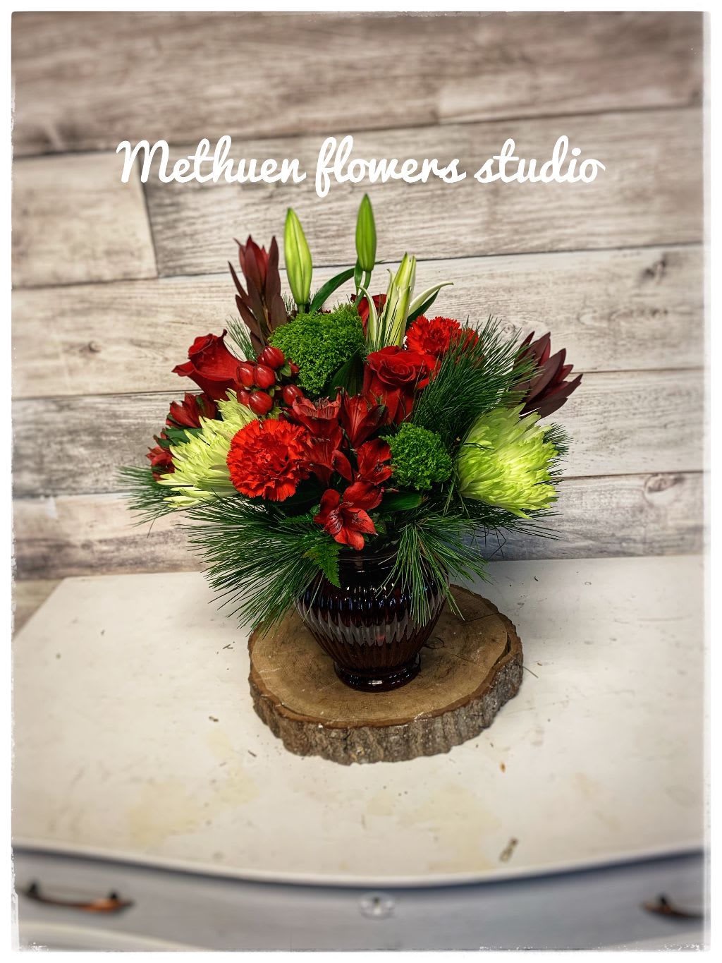 christmas cheer - red vase with red roses, green fugi, hypericum and other fresh xmas flowers