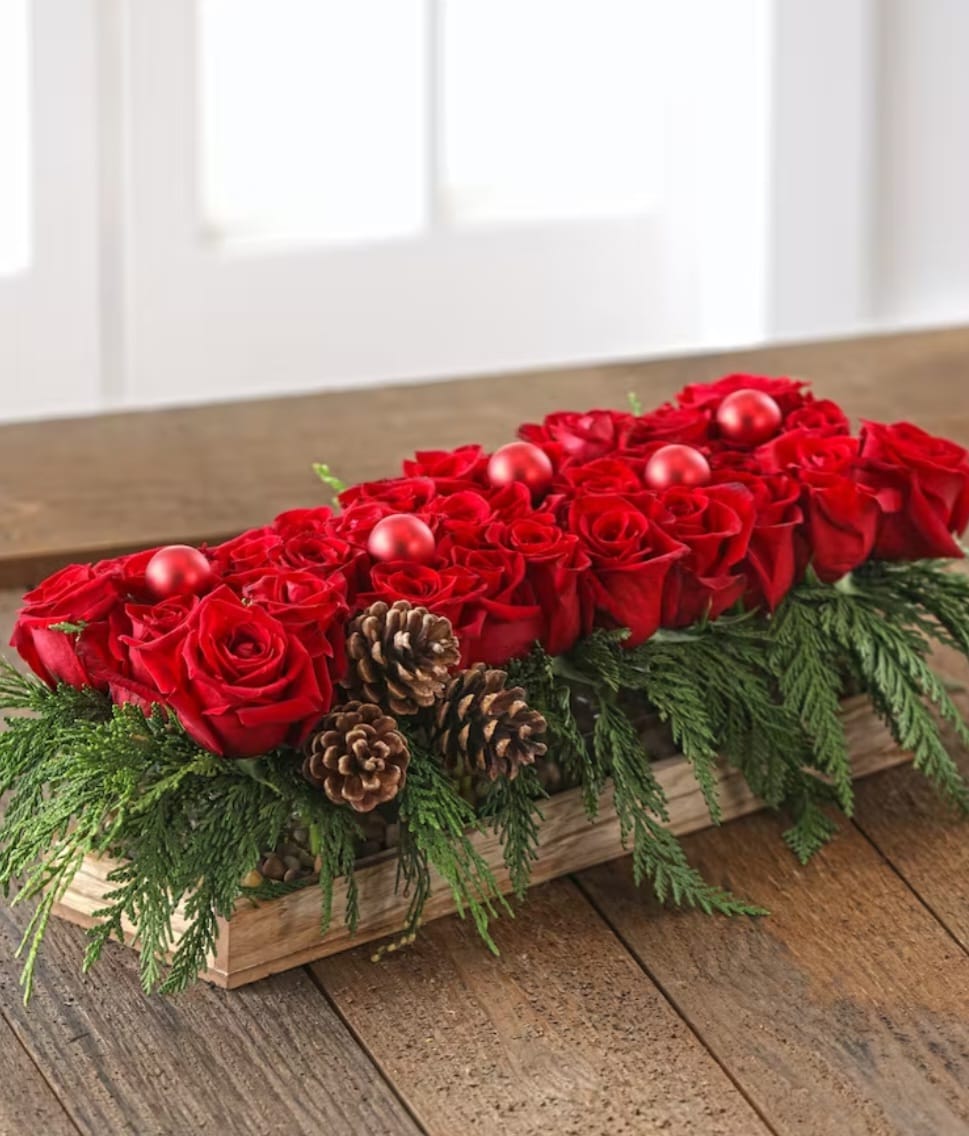 Festive Luxury Christmas  - They will love this gift of holiday magic! Over 30 luxury premium roses nestled in scented cedars, pine cones and adorned with holiday ornaments.  This arrangement measures 20&quot; long  24&quot; including the winter greens. 
