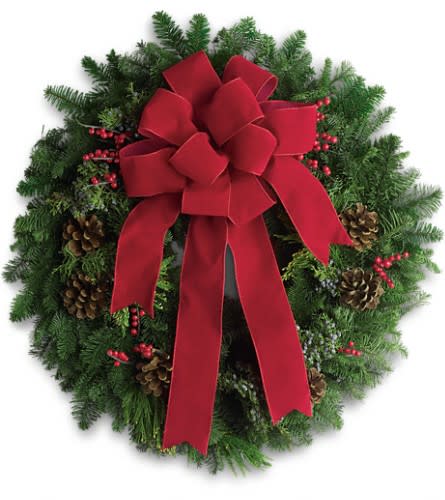 Classic Holiday Wreath - The holidays are knocking at the door. Luckily here's a gift that always gets a warm welcome! It's a classic holiday wreath with some very lovely extras. A beautiful noble fir wreath with juniper branches pinecones and berry sprays is adorned with a brilliantly festive red velvet bow. Anyone would be delighted to have this arrive on their doorstep