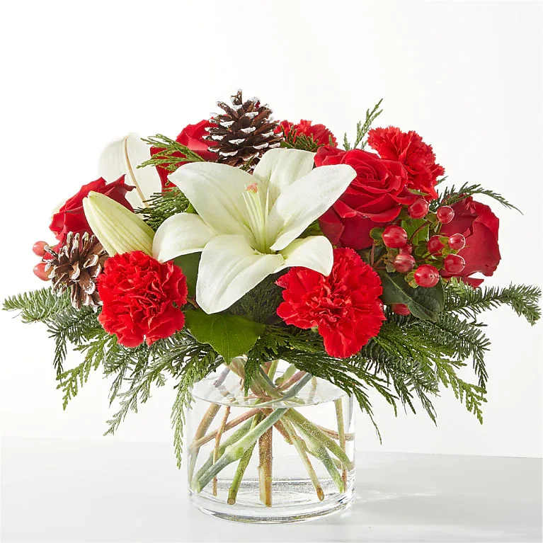 Oh So Jolly Bouquet - This bouquet is sure to shimmer as bright as the holiday lights with lush carnations, roses, and lilies bursting from the vase.