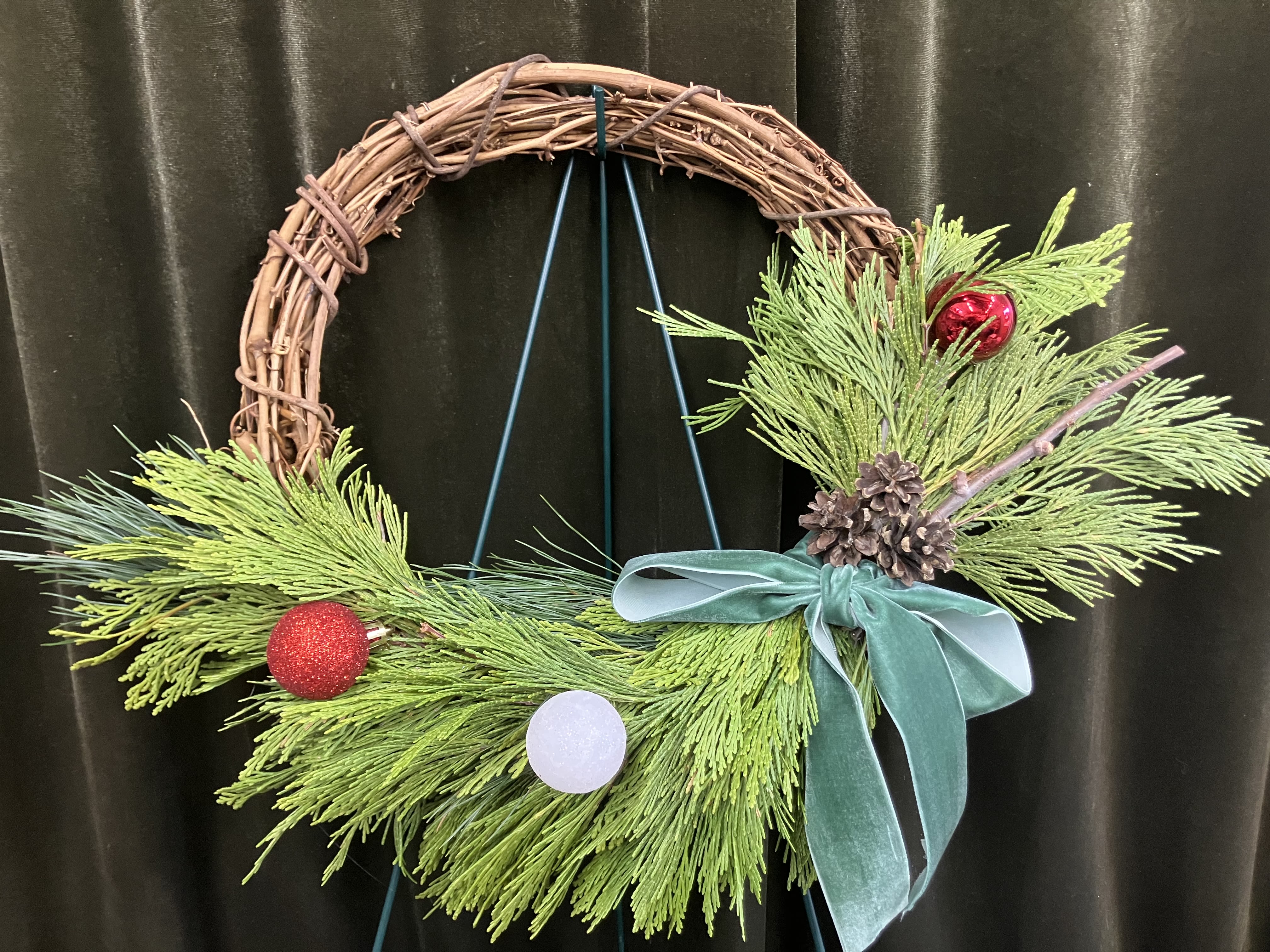 DIY Wreath Kit - Stay inside where it’s warm and create a cute grapevine evergreen wreath! Kit includes supplies of one 12” grapevine wreath, evergreens, 1.5 yard ribbon, 3 mini pine cones, 3 mini ornaments and 2 yards of wire! Comes in a nice grab bag   Ribbon will vary 