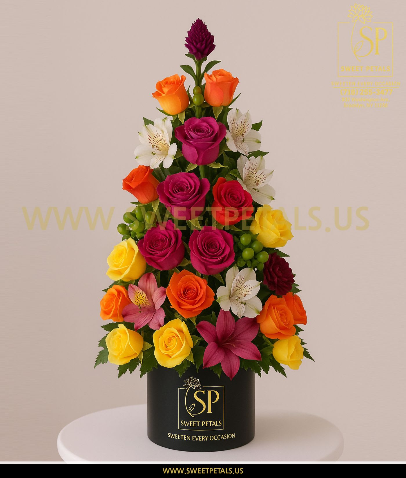 Vibrant Harmony Tower Vase – Flowers Tree by SweetPetals - The Vibrant Harmony Tower Vase – Flowers Tree by SweetPetals is a joyful explosion of color, expertly designed in a striking tower silhouette that resembles an elegant flower tree. Featuring a radiant blend of fuchsia roses, sunset-orange roses, bright yellow roses, white alstroemeria, deep burgundy blooms, lush greens, and seasonal fillers, this arrangement brings a lively and uplifting energy to any space.  Crafted in our signature SweetPetals black vase, this structured Flowers Tree design adds height, elegance, and artistic beauty—perfect for birthdays, celebrations, congratulations, housewarmings, get-well gifts, or simply brightening someone’s day. Each bloom is hand-selected for freshness, vibrancy, and perfection, ensuring a long-lasting floral display.  The Vibrant Harmony Tower Vase – Flowers Tree is more than an arrangement—it’s a radiant statement piece that sweetens every occasion with color, cheer, and floral luxury.   SweetPetals – Sweeten Every Occasion. 
