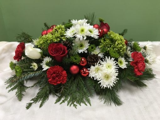 Traditional Christmas Centerpiece - Your loved ones will be feeling merry and bright when they receive this centerpiece of traditional holiday spirit. With red spray roses, red carnations, white cushion poms and Christmas greens, 