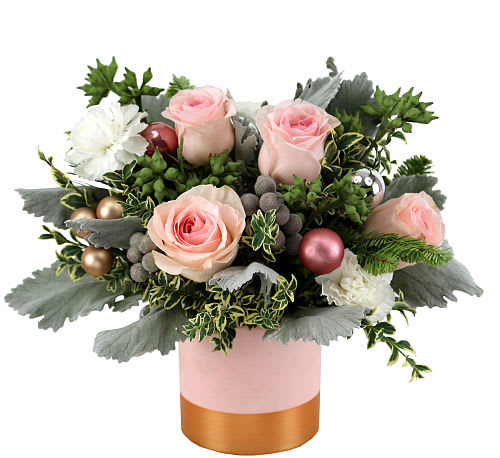 Pink Frost  - Embrace the serene beauty of winter with our &quot;Pink Frost .&quot; Delicate blush roses and white carnations capture the essence of a tranquil snowy landscape, accented by the gentle hues of pink and silver balls. A lush assortment of greens, including festive holiday foliage, provides a backdrop for the seasonal charm.