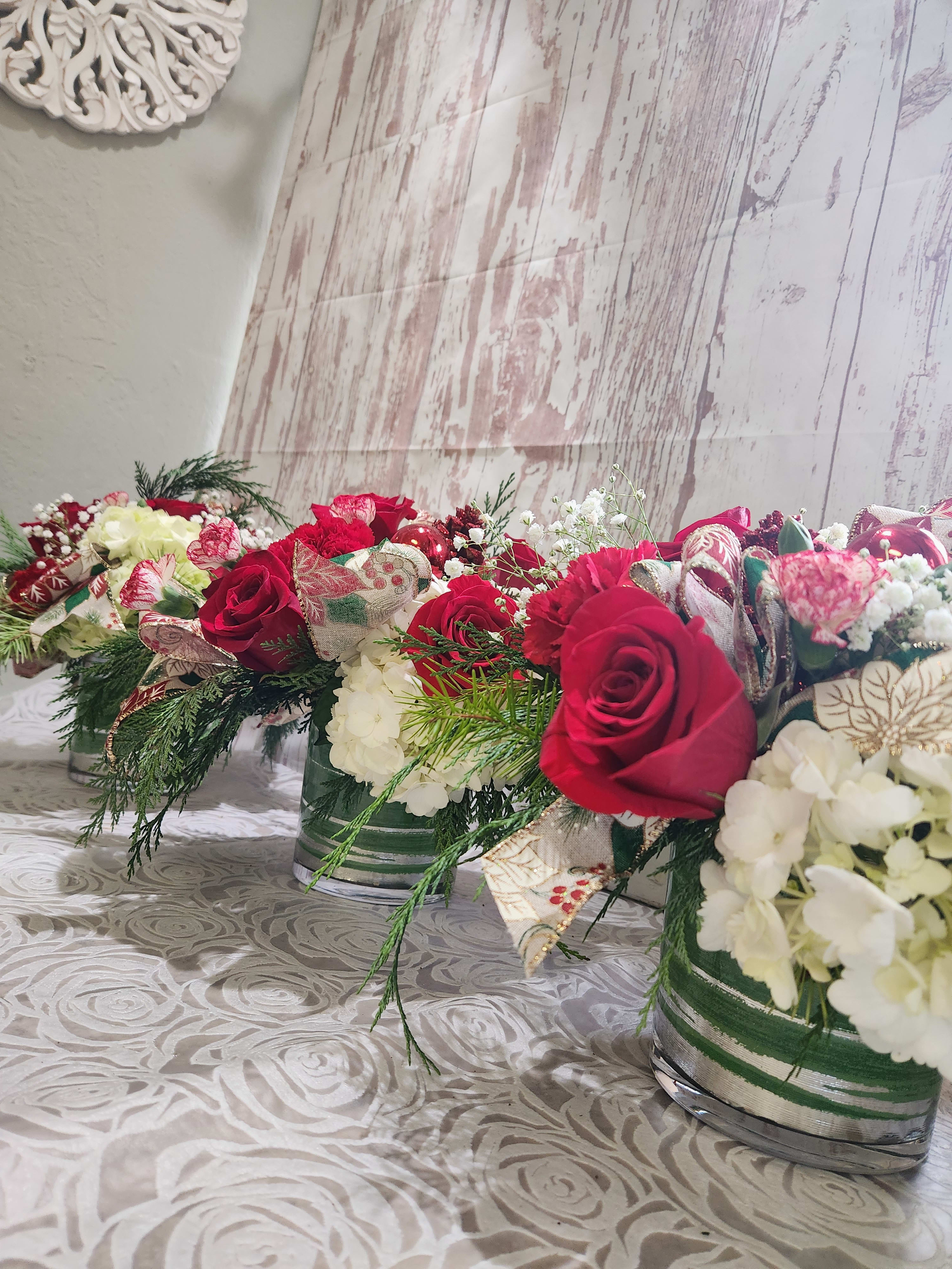 Holiday Pack  - It's December and there is holiday cheer and  gathering's, cooperate events, elegant family dinners and you must dress up the house or venue with flowers let us take care of that little part. We can follow  a theme or do classic traditions designs. We have sets of 3  5 or 7 arrangements. We can design in a cylinder or cube style vase depending on inventory.    