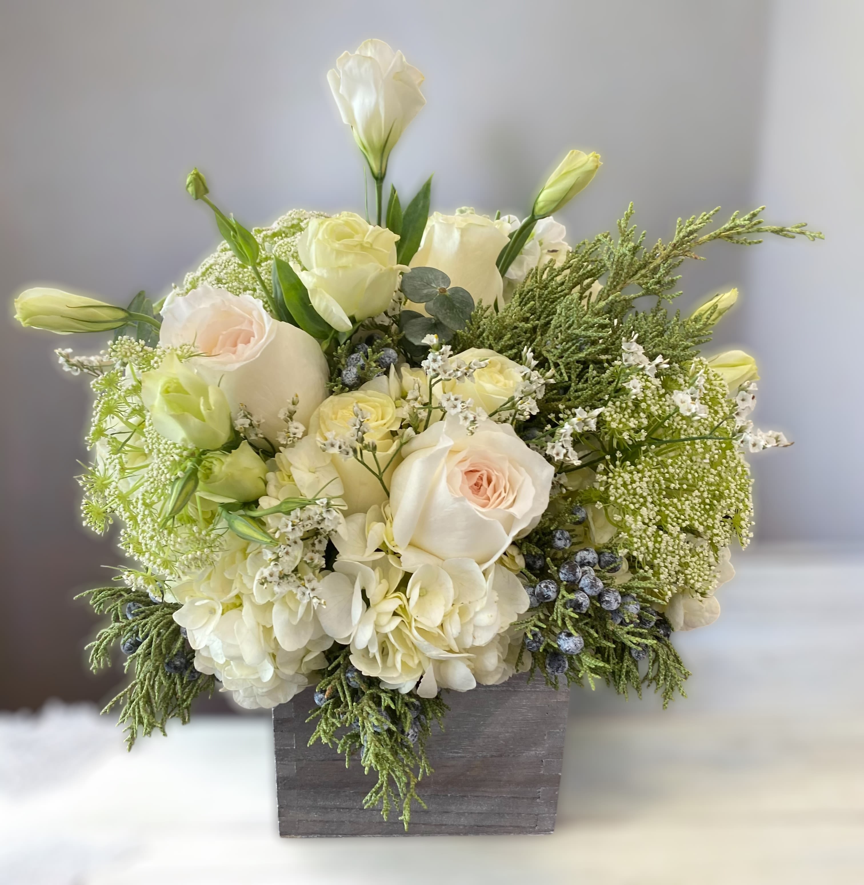 English Holiday  - Perfectly fit for the Queen in your life, this bouquet is decked out with the most delicate of winter blooms in a silver box 