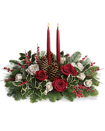 Christmas Wishes Centerpiece - Your wishes for a classic Christmas centerpiece have come true! This elegant arrangement features two glowing red taper candles atop a bed of noble fir, white pine and luxurious roses.Red and white roses are mixed with festive noble fir, white pine and variegated holly beneath two red taper candles. Red berries and pine-cones add to the Christmas fun.