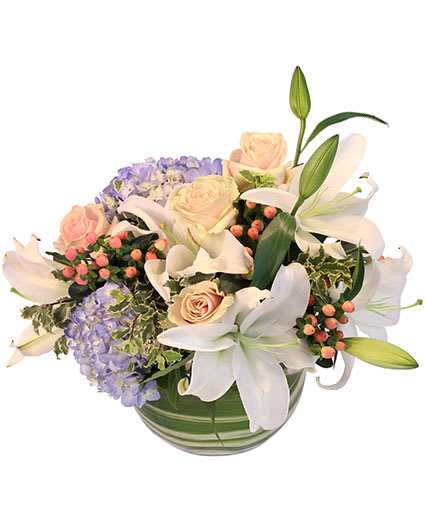 AURA OF WINTER FLORAL DESIGN - This beauty adds a colorful twist to your winter decor! Bring the season indoors with our beautiful Aura of Winter arrangement! With blue hydrangea, white oriental lilies, blue hypericum, light pink roses, and more, this blooming design is the perfect way to bring some warmth into your home. 